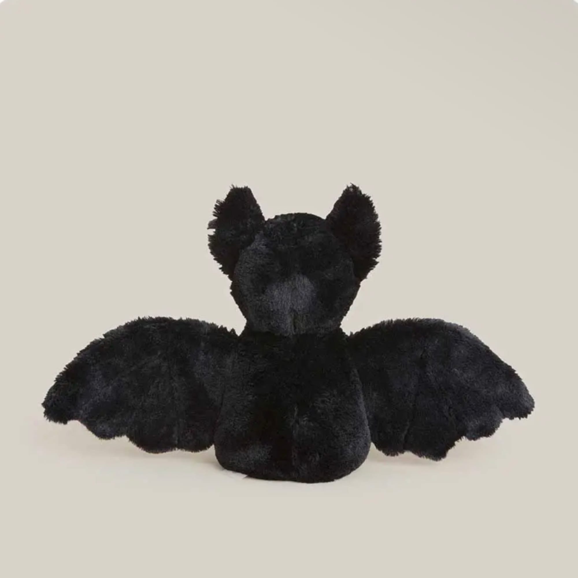 Black plush bat with outstretched wings on a plain background
