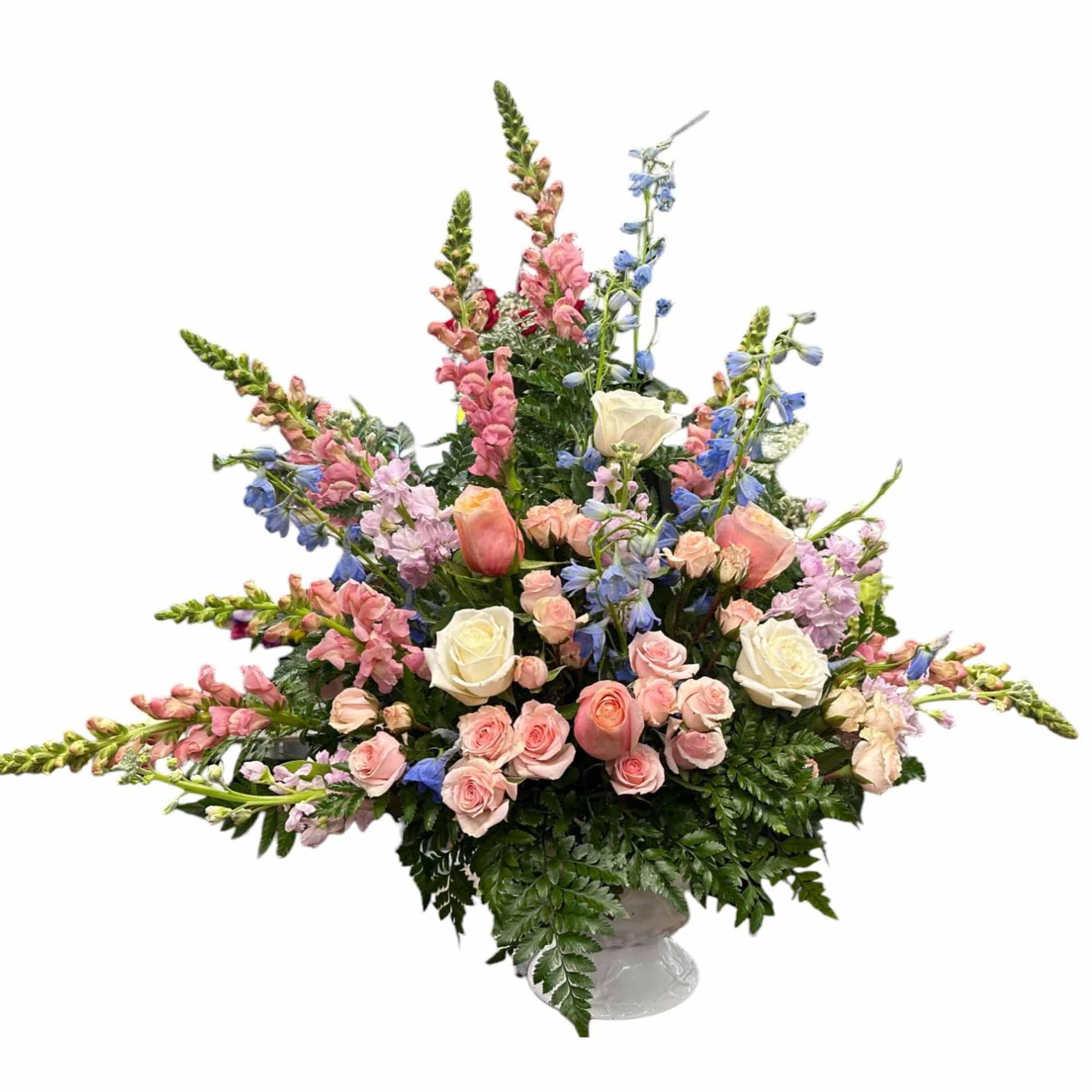Large pastel bouquet with roses, snapdragons, and blue flowers in a vase