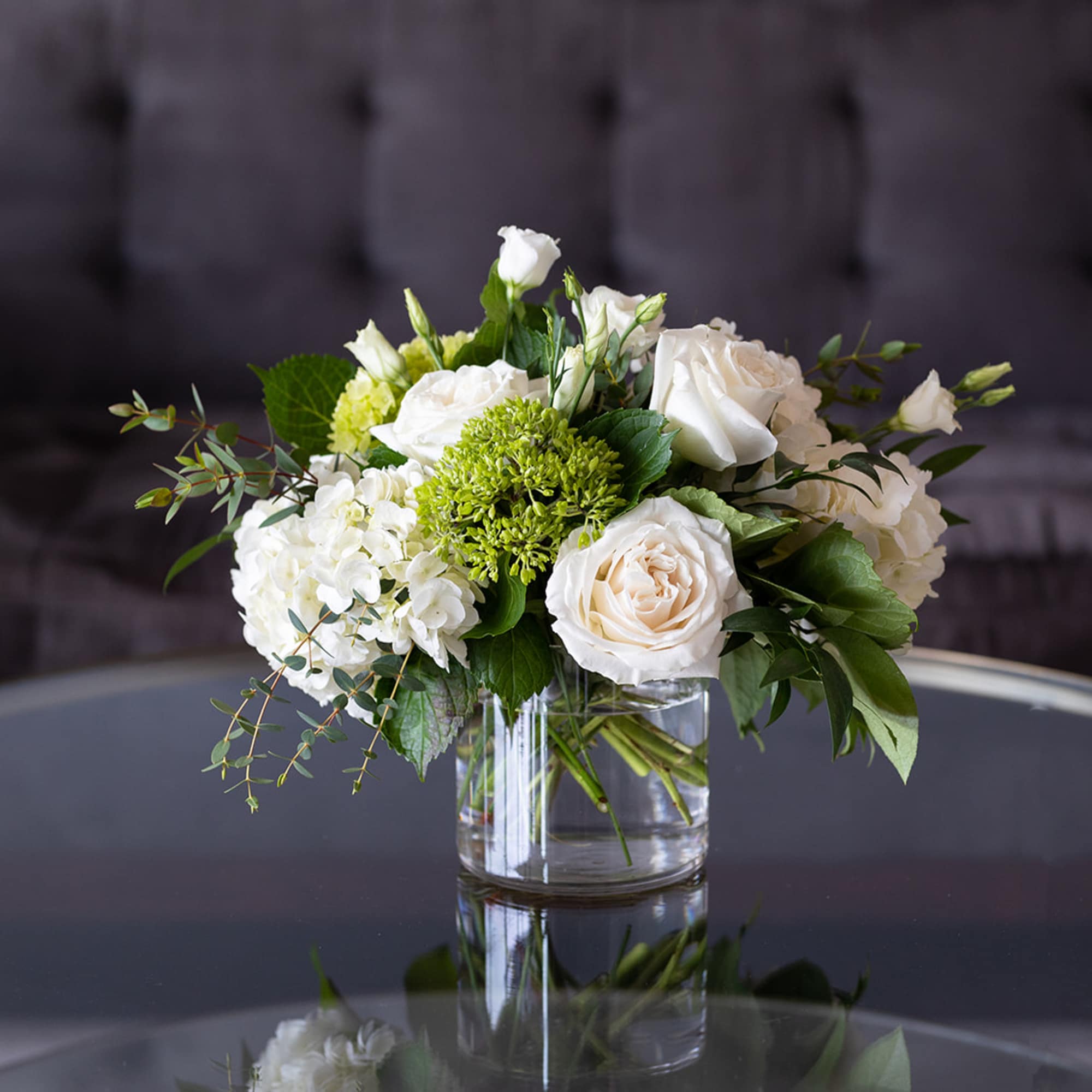 White floral arrangement in a clear glass vase on a table
