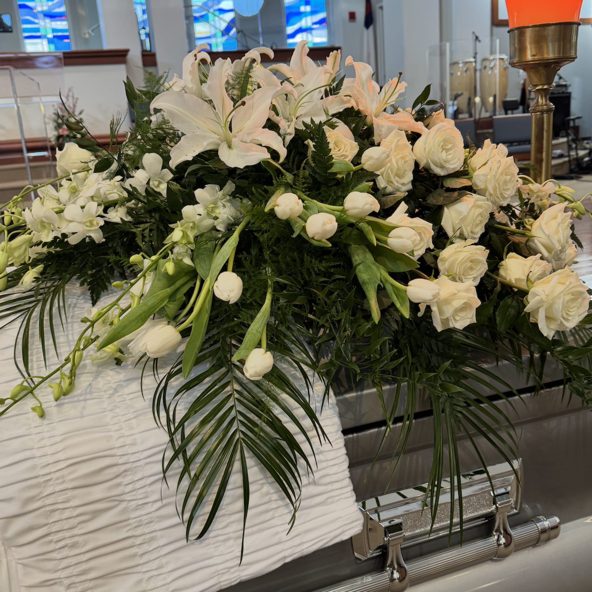 White floral casket spray with lilies and roses