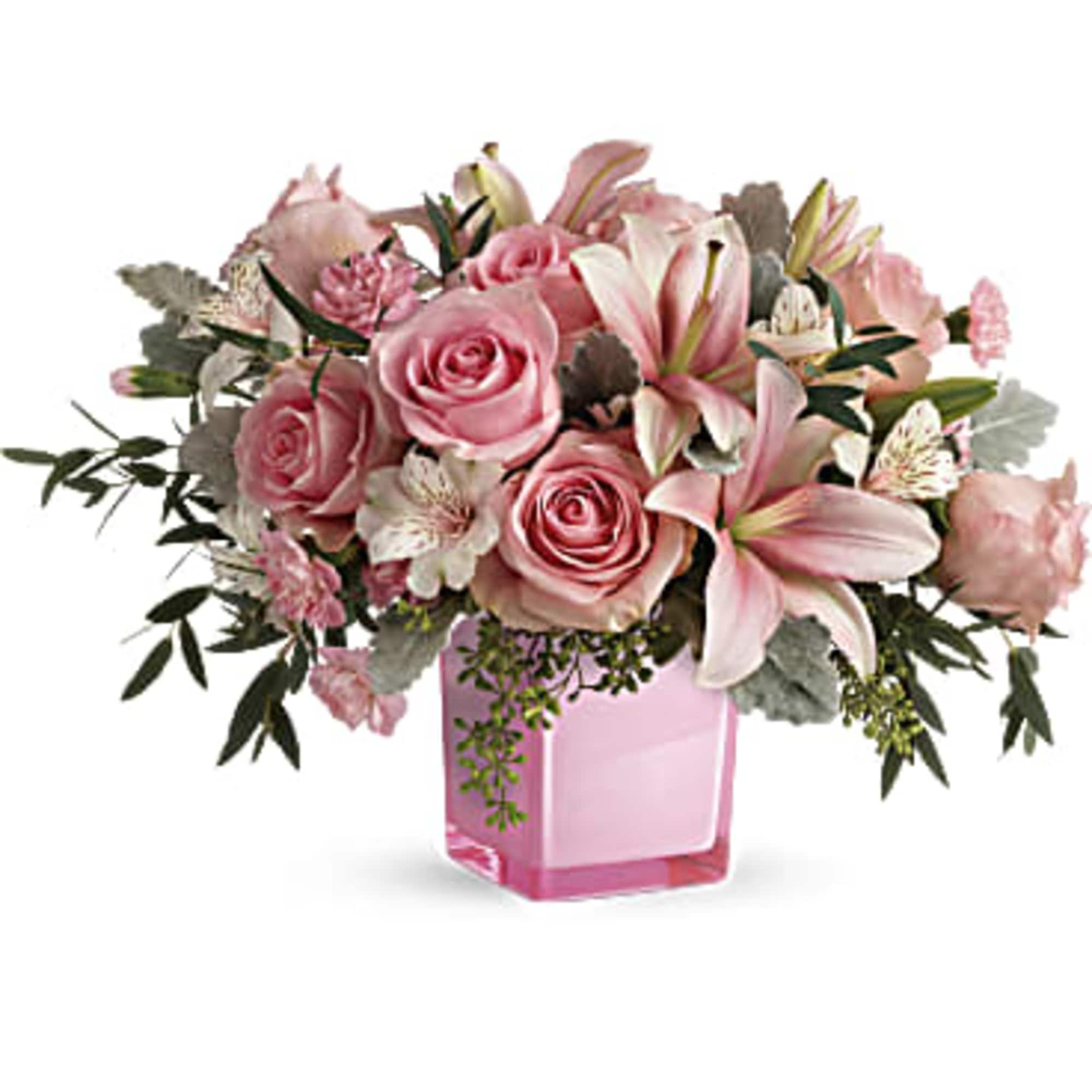 Pink roses and lilies arranged in a pink glass vase