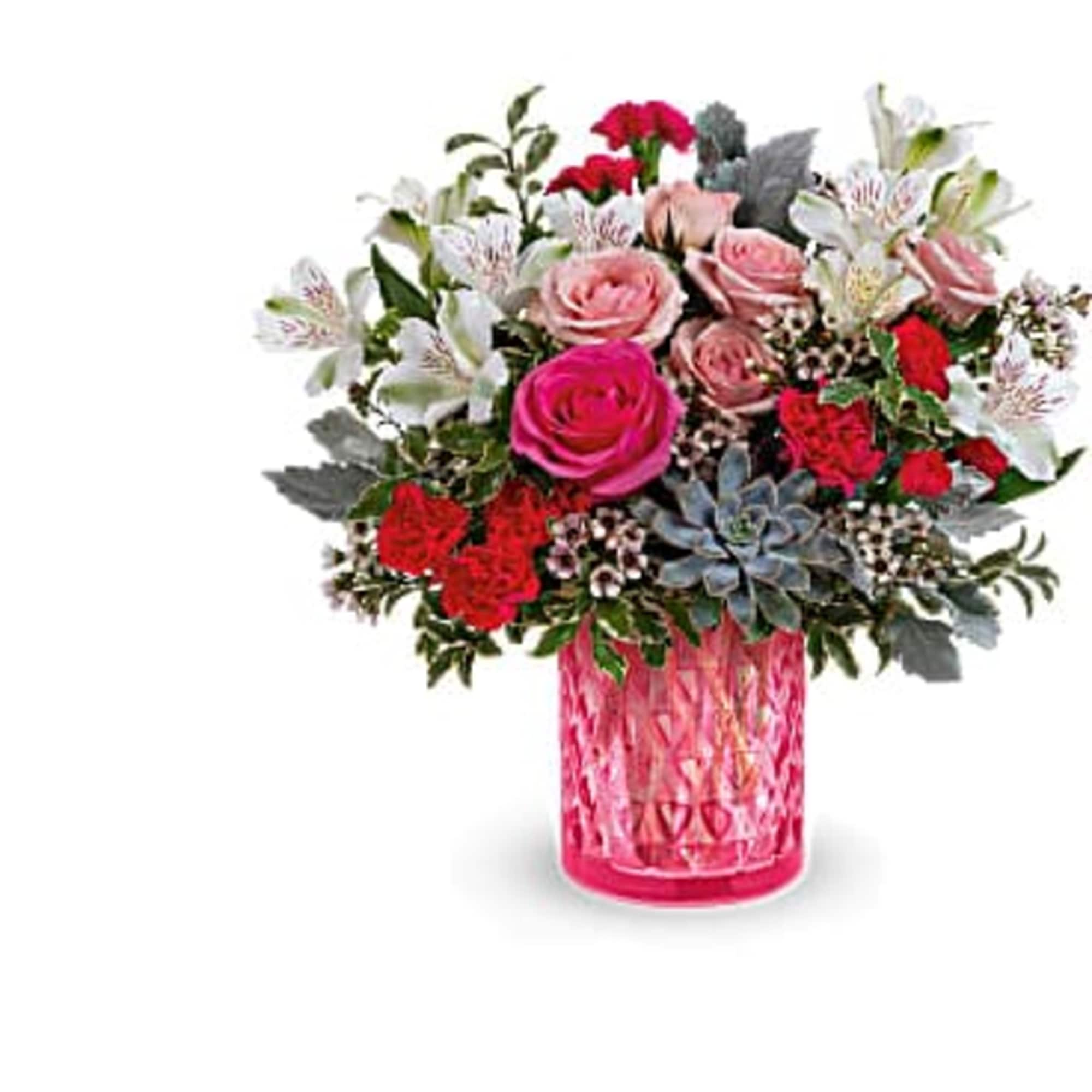 Pink and red mixed flower arrangement in a pink glass vase
