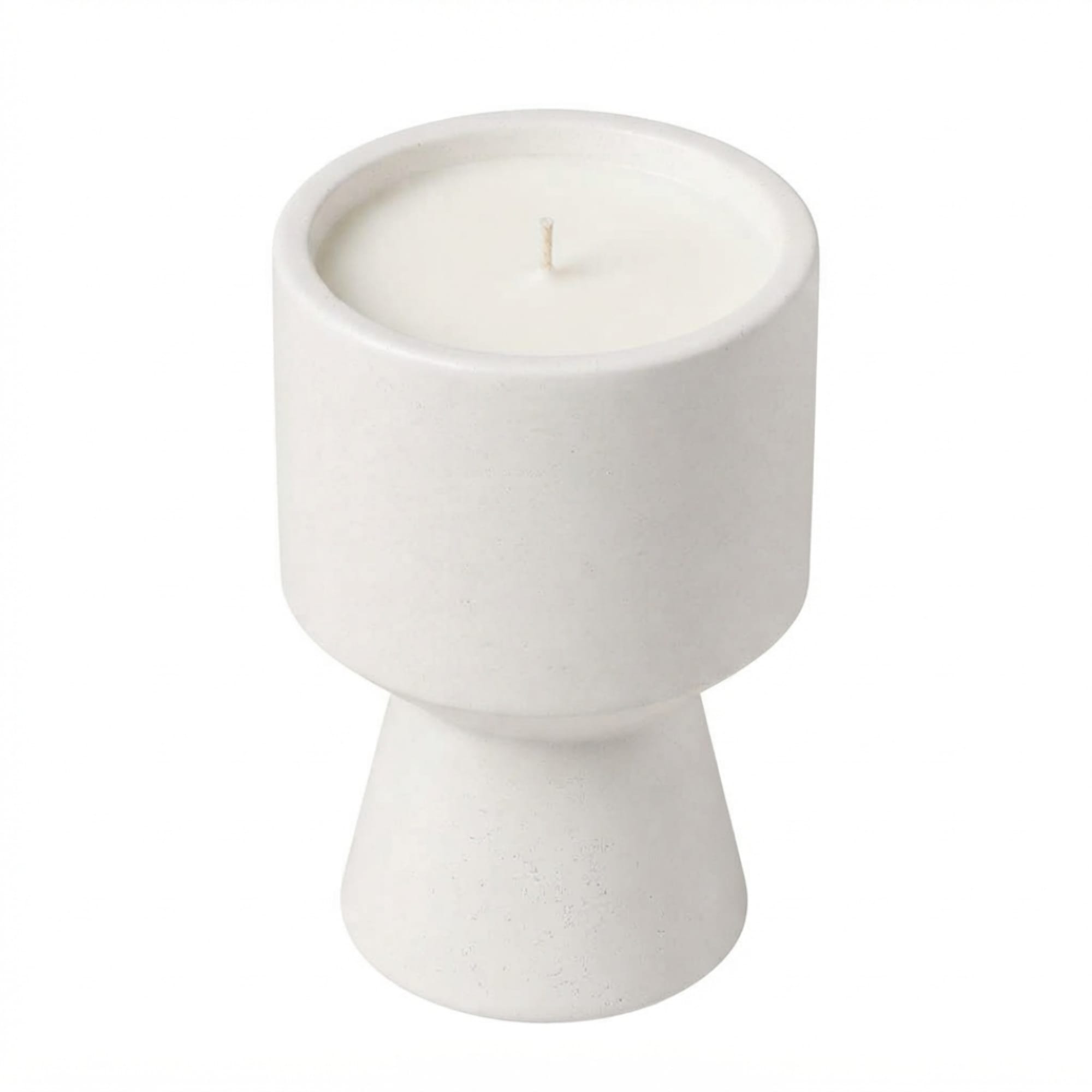 White candle in a pedestal-style ceramic holder