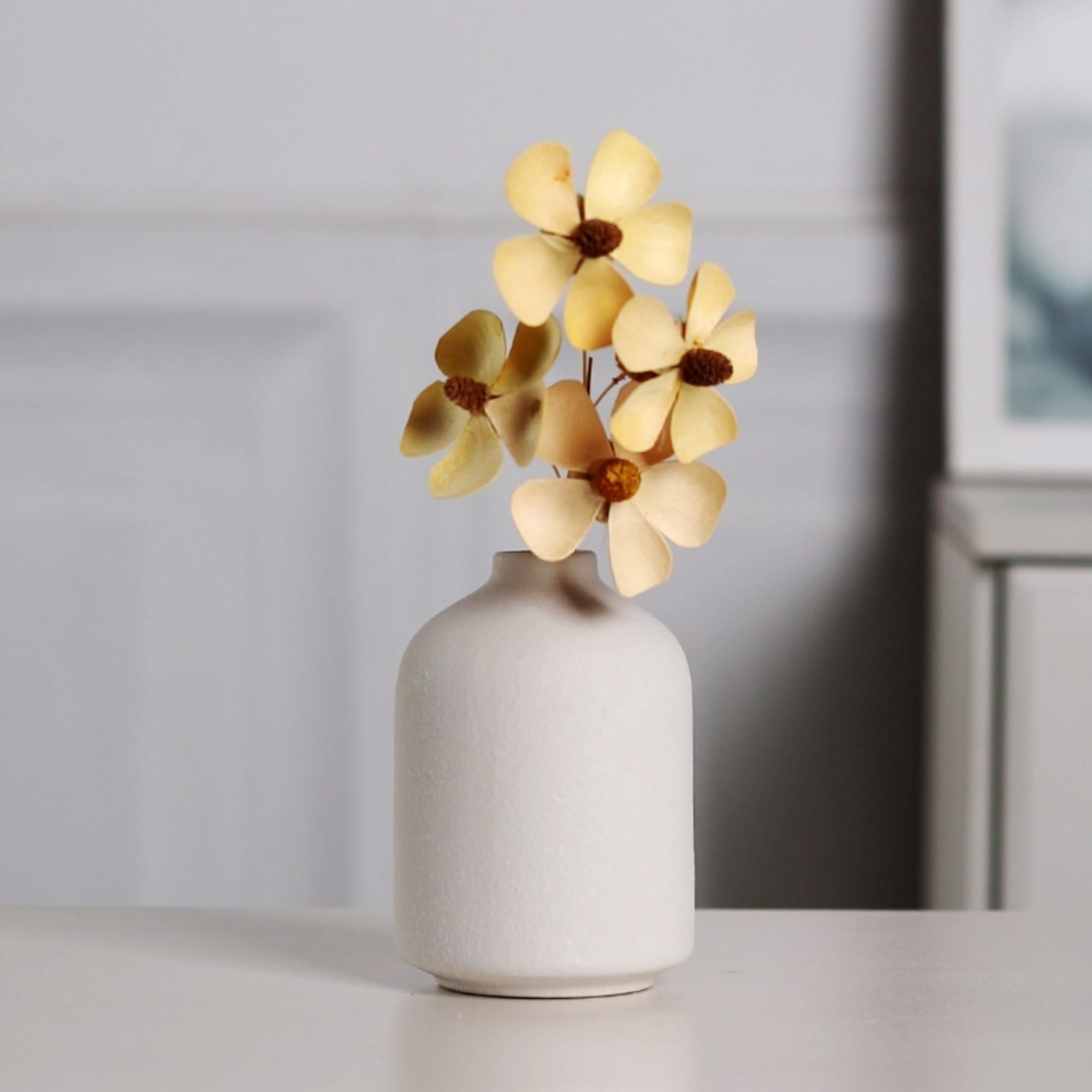Yellow flowers in a white ceramic vase