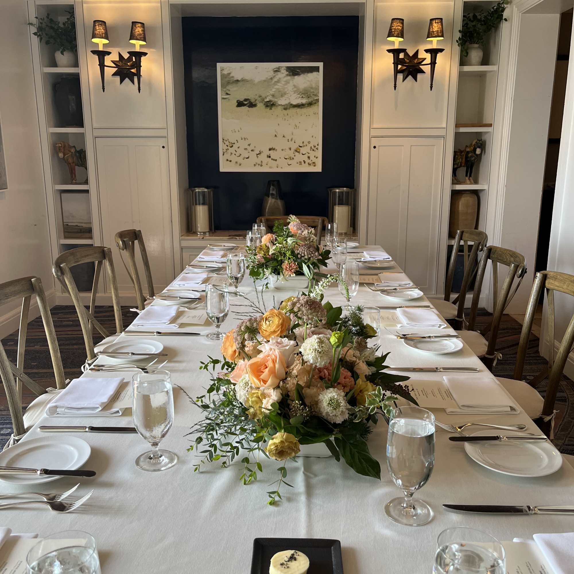 Long banquet table with peach and cream floral centerpieces