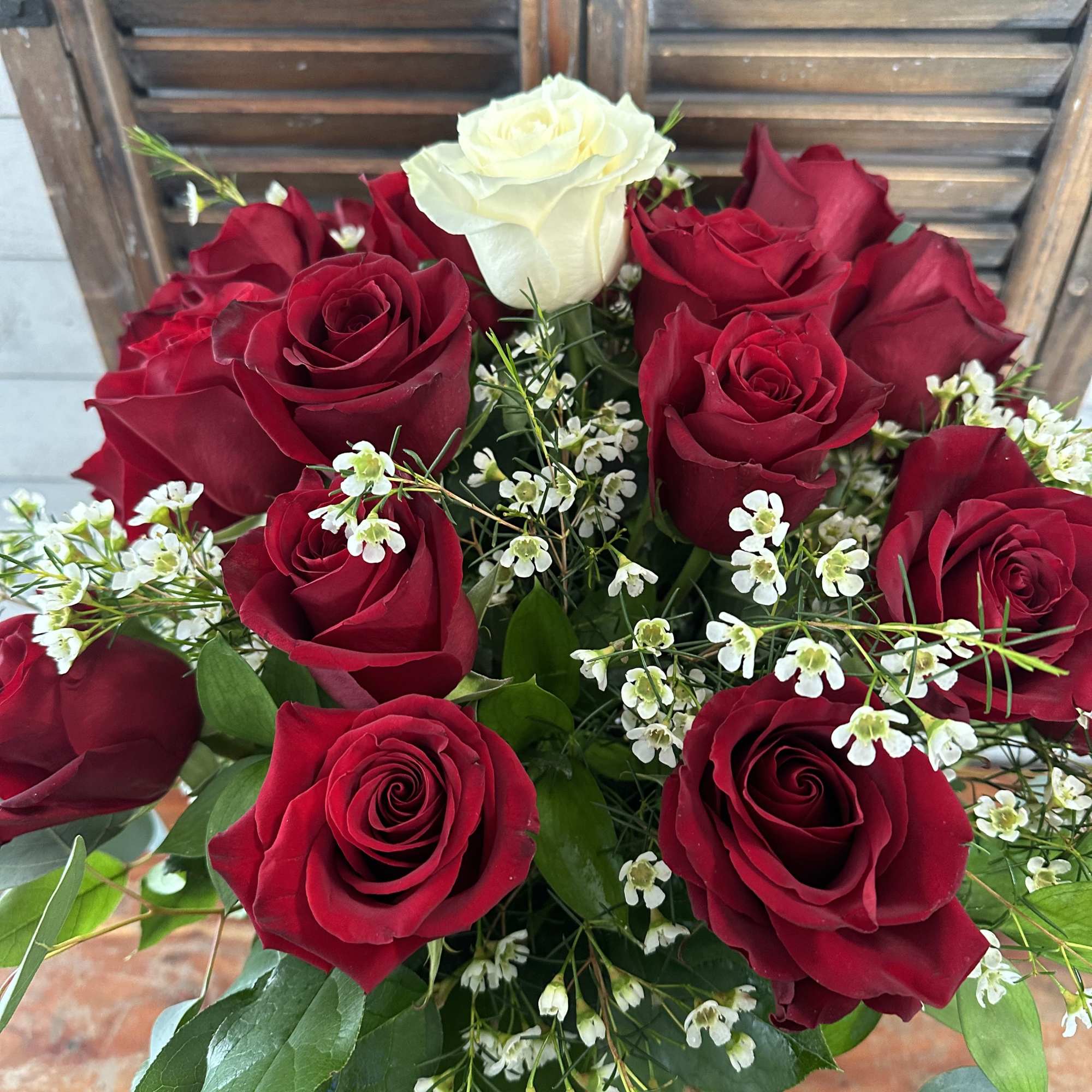 Bouquet of red and white roses with small white filler flowers, photo 2 of 3