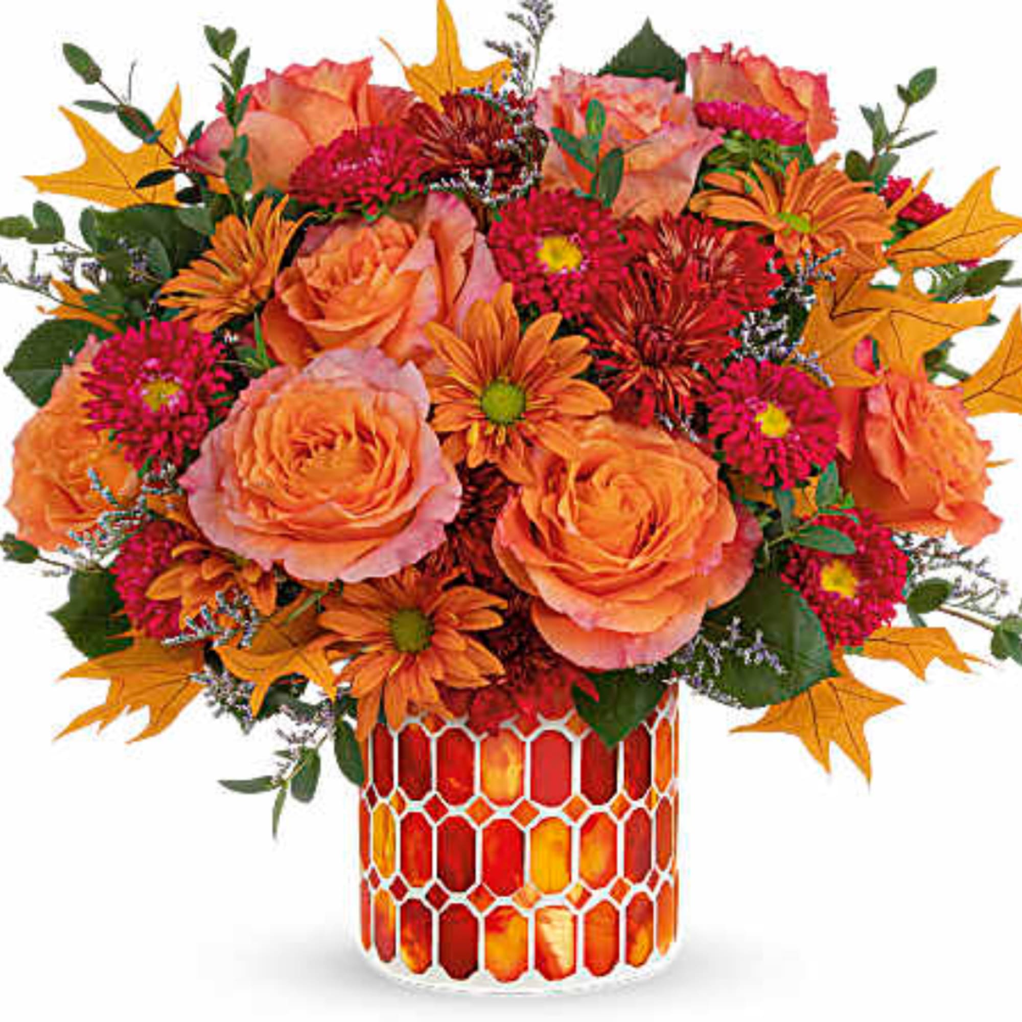 Orange and pink floral arrangement in a patterned glass vase