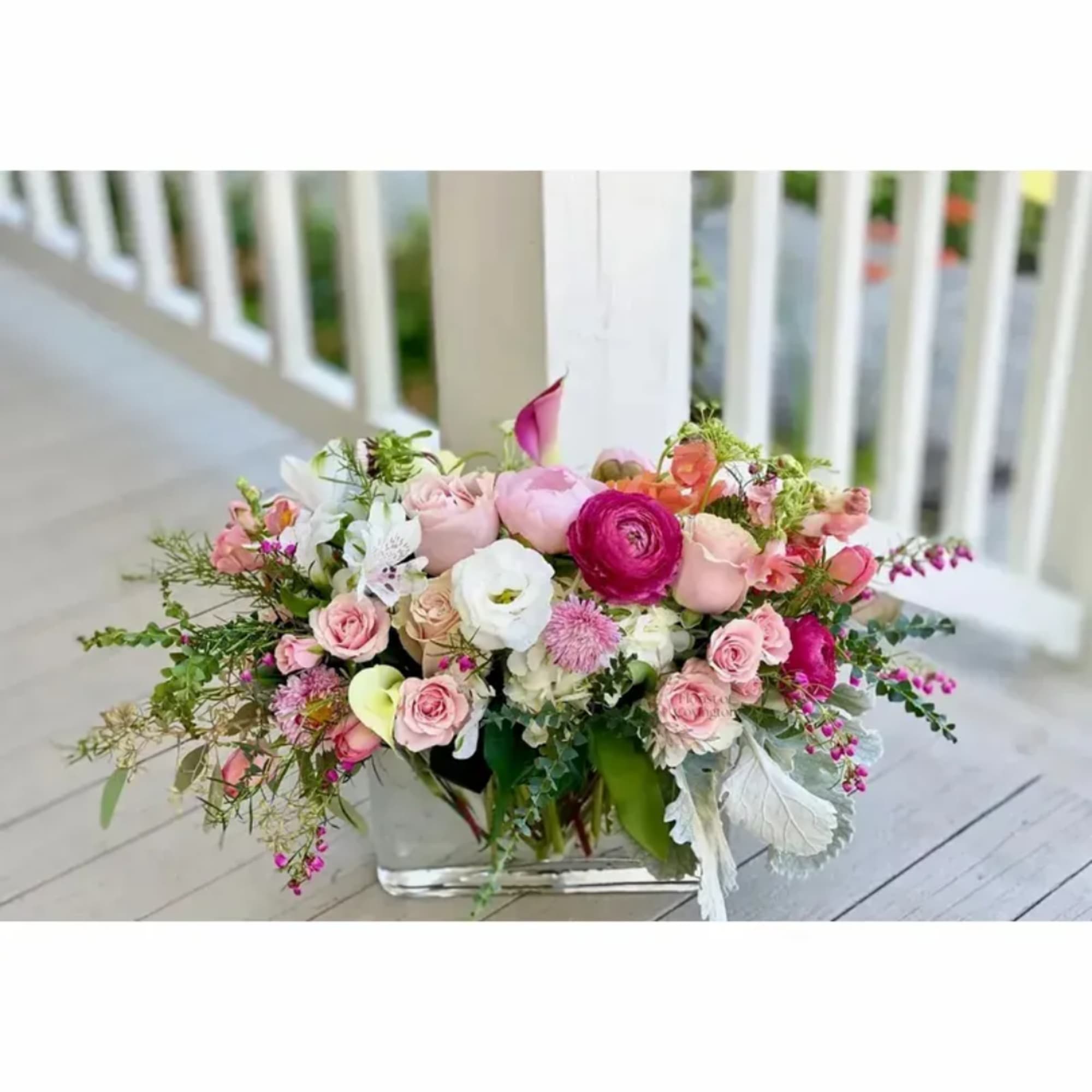 Mixed pink and white flower arrangement in a clear rectangular vase
