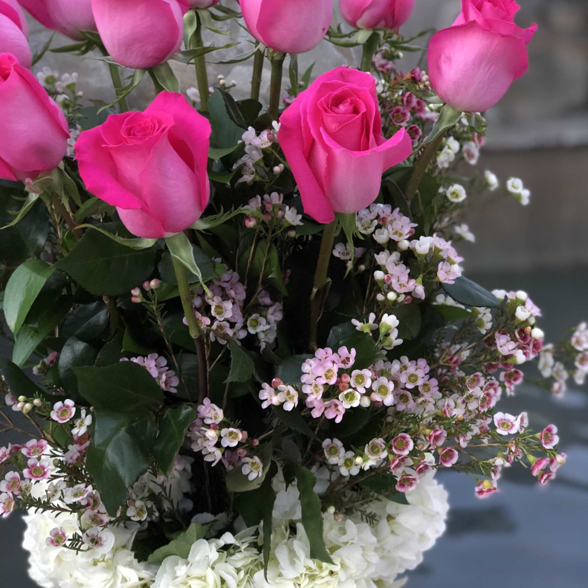 Pink roses with white hydrangeas and small filler flowers in a bouquet
