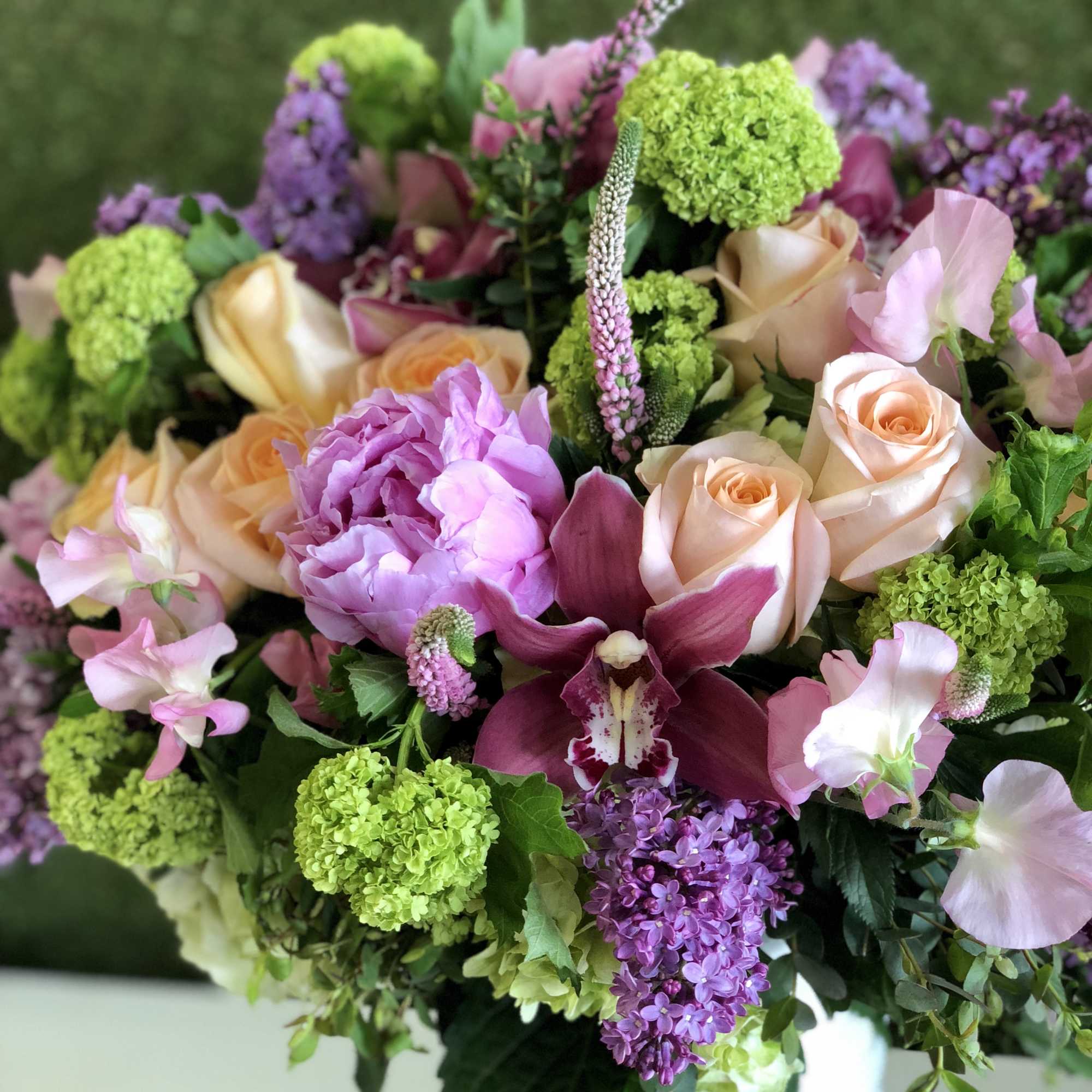 Bouquet of peach roses, purple orchids, and green hydrangeas