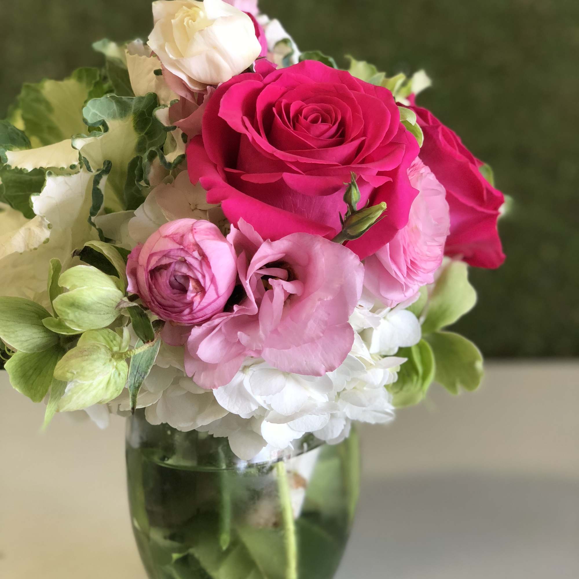 Pink and white roses with hydrangeas in a glass vase