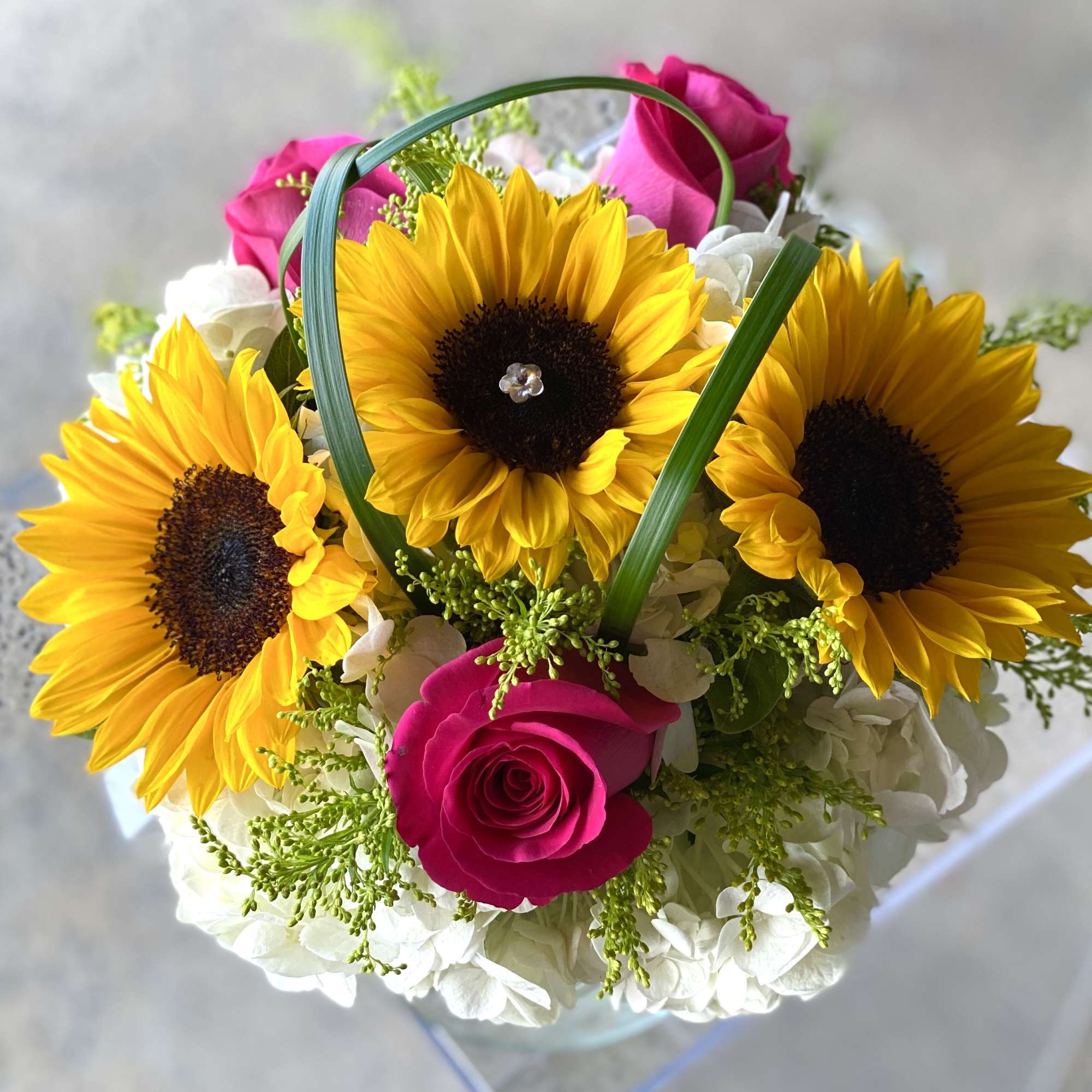 Bouquet of sunflowers, pink roses, and white hydrangeas