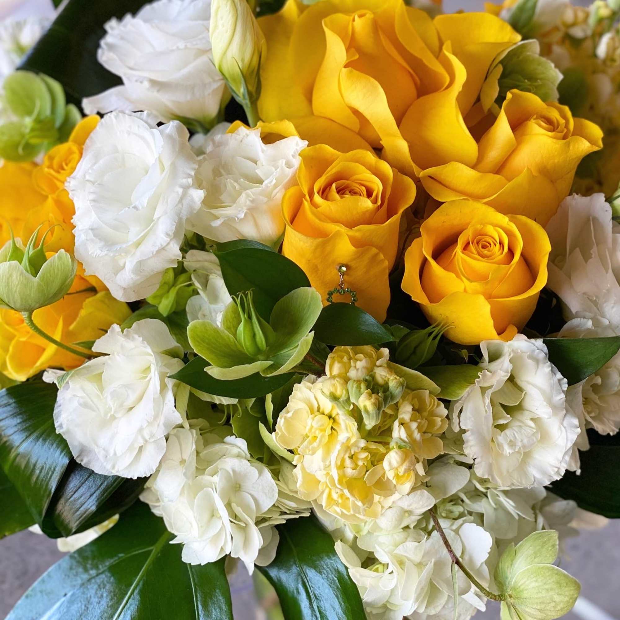 Bouquet of yellow roses and white lisianthus with green accents