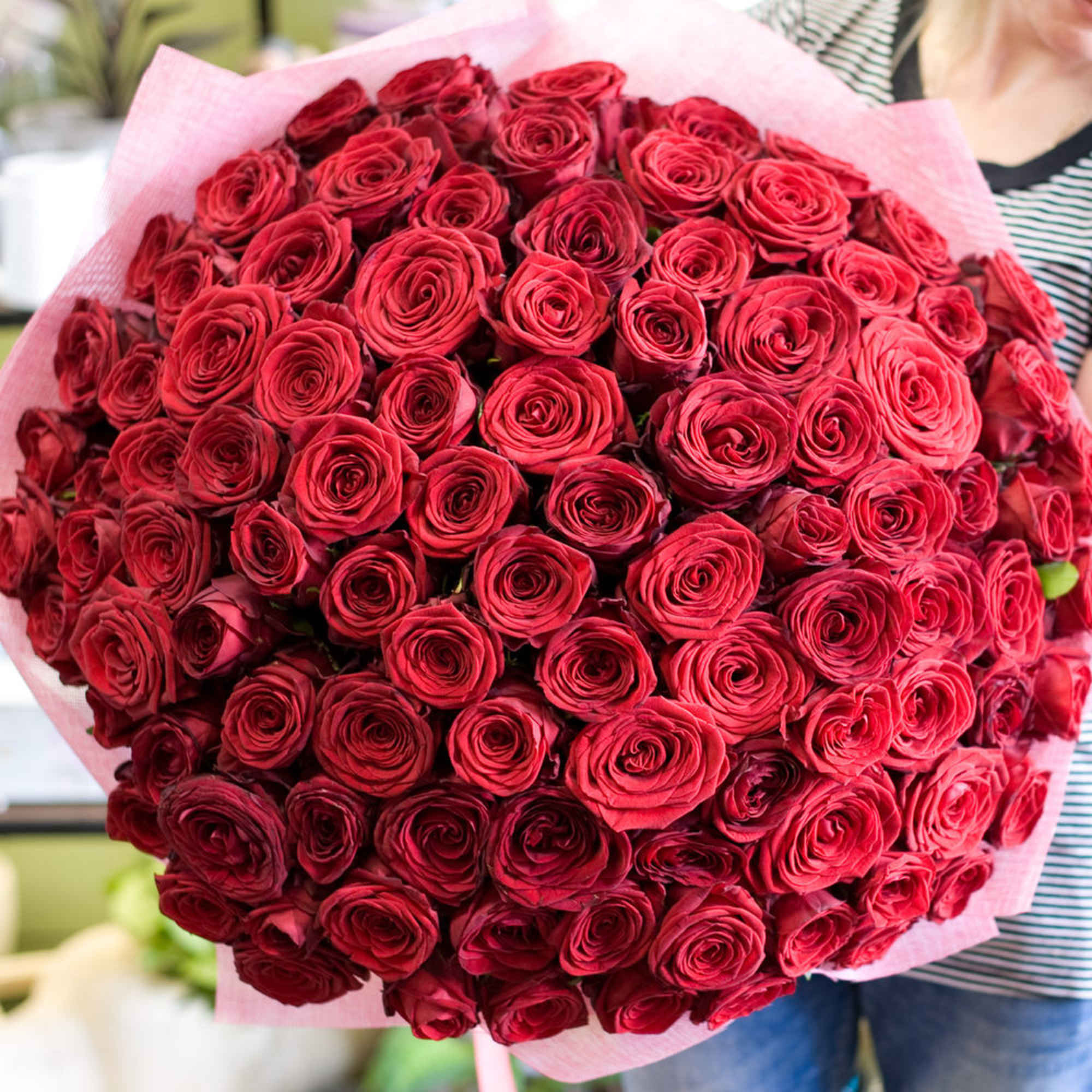 Large bouquet of red roses wrapped in pink paper