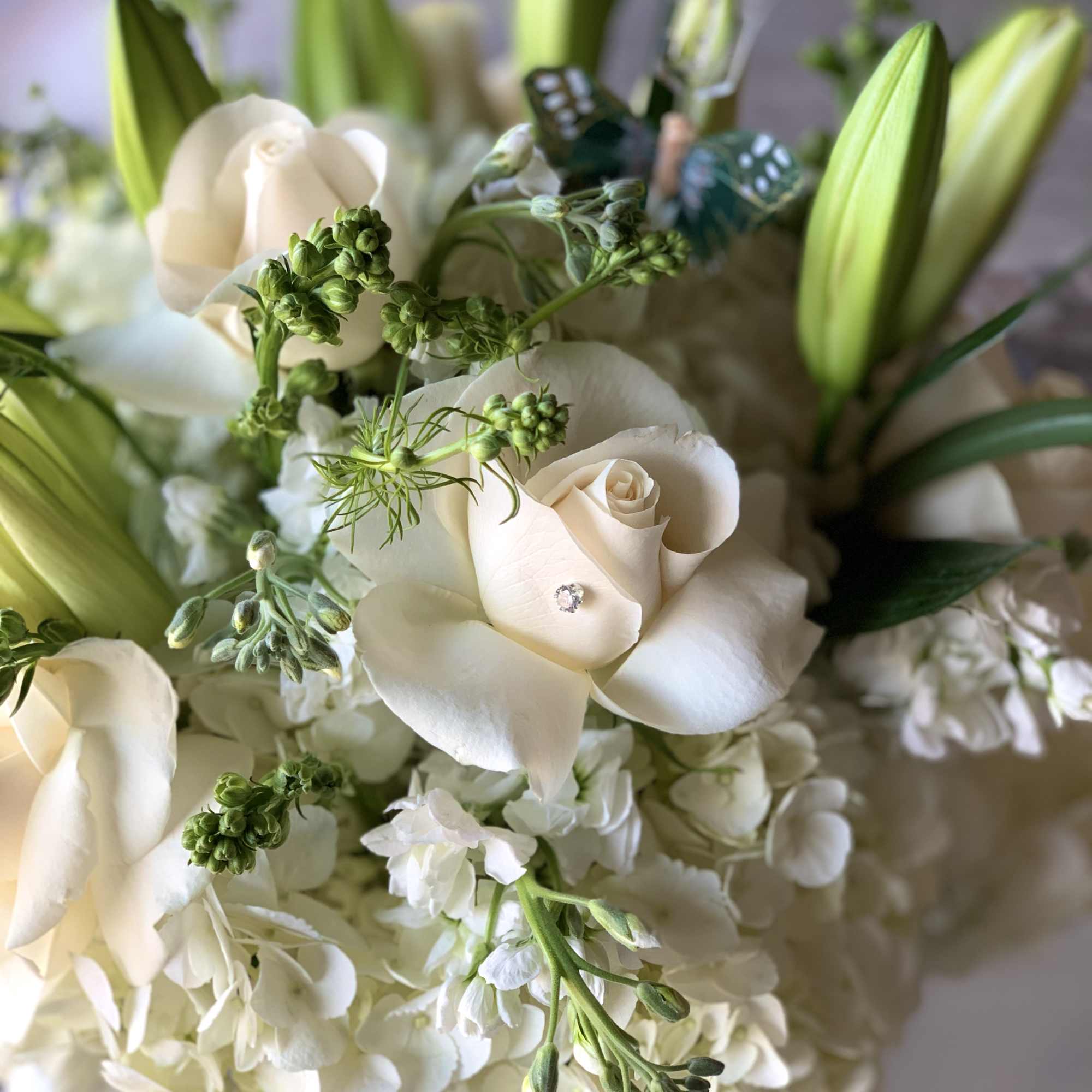 White roses and lilies in a bouquet with green buds