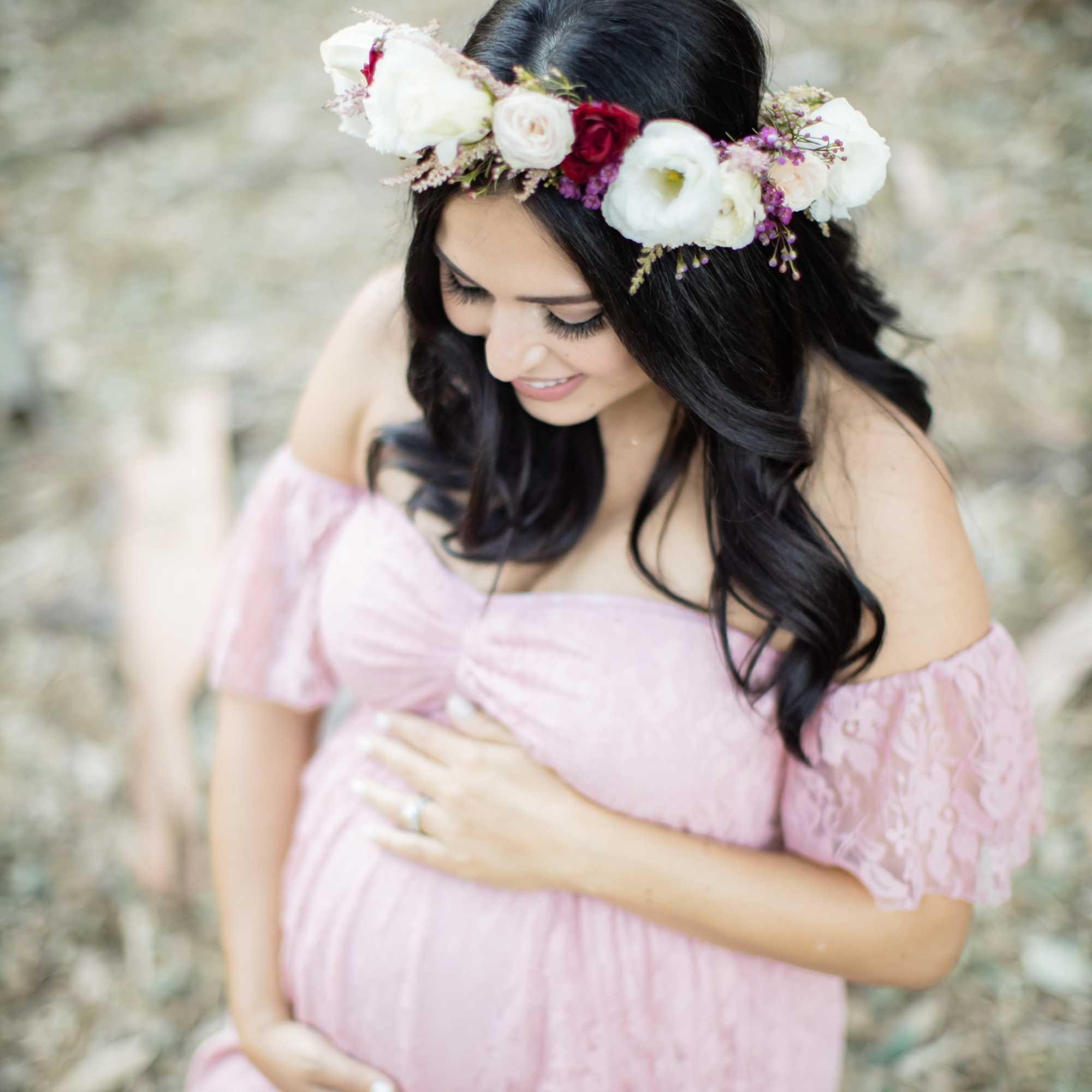 Pregnant woman in a pink dress wearing a floral crown