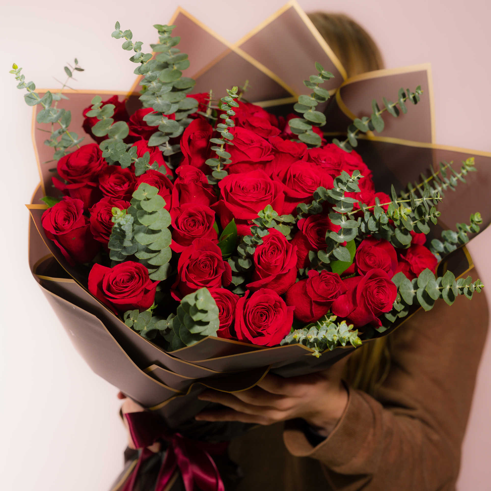 Bouquet of red roses with eucalyptus in brown wrap
