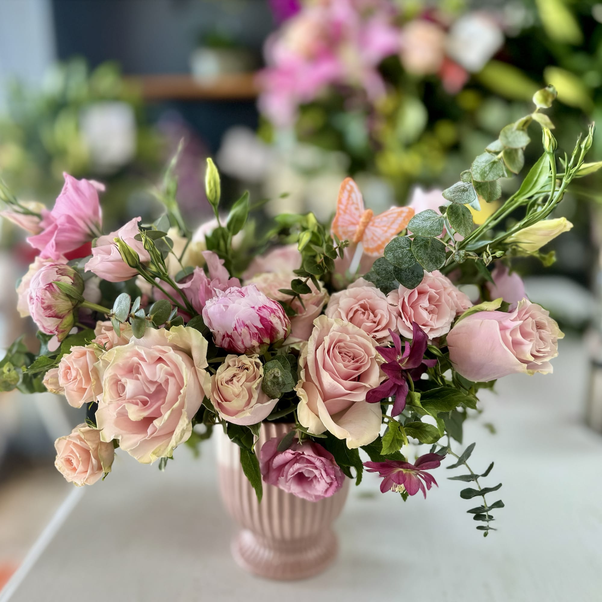 Pink roses and lisianthus arranged in a ribbed pink vase