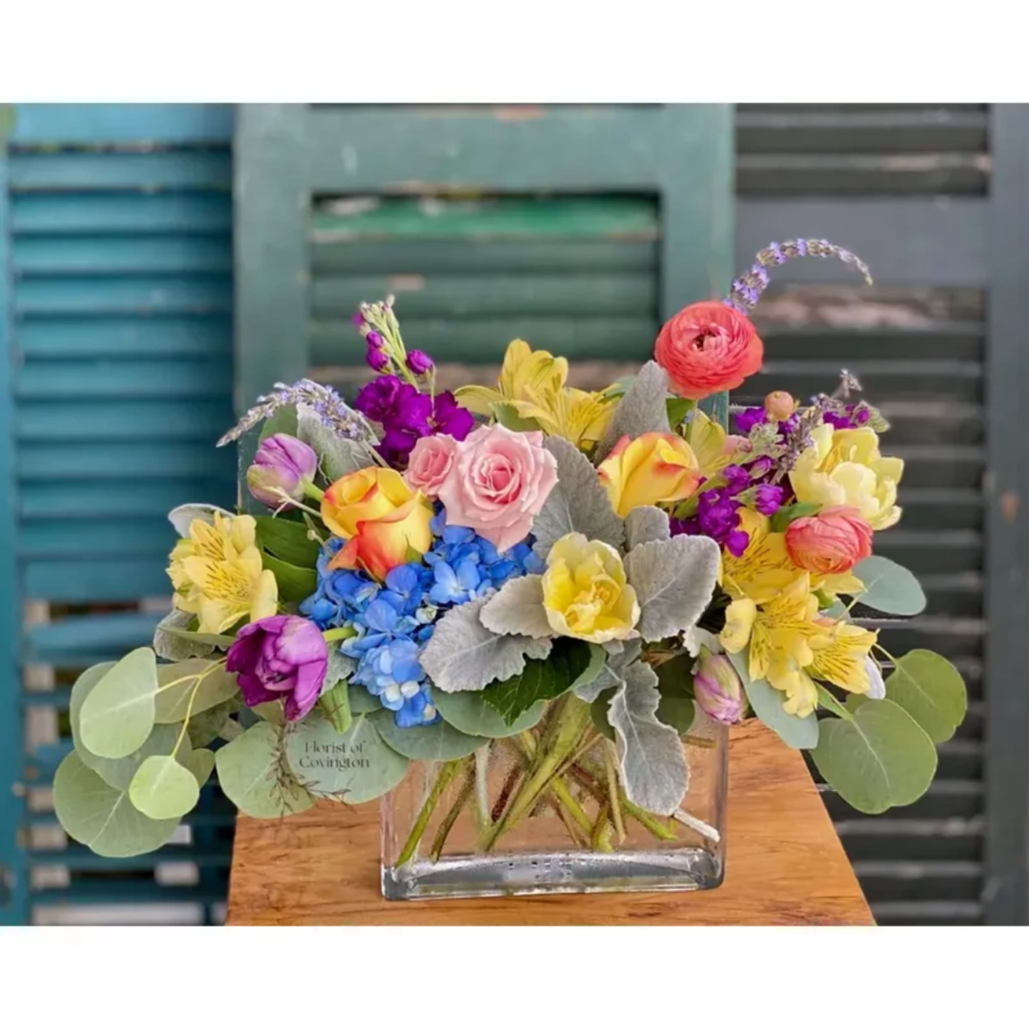 Colorful mixed bouquet in a clear square glass vase