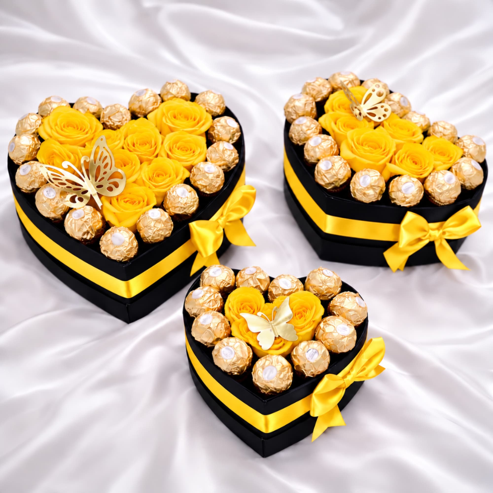 Heart-shaped gift boxes with yellow roses and chocolates on satin fabric