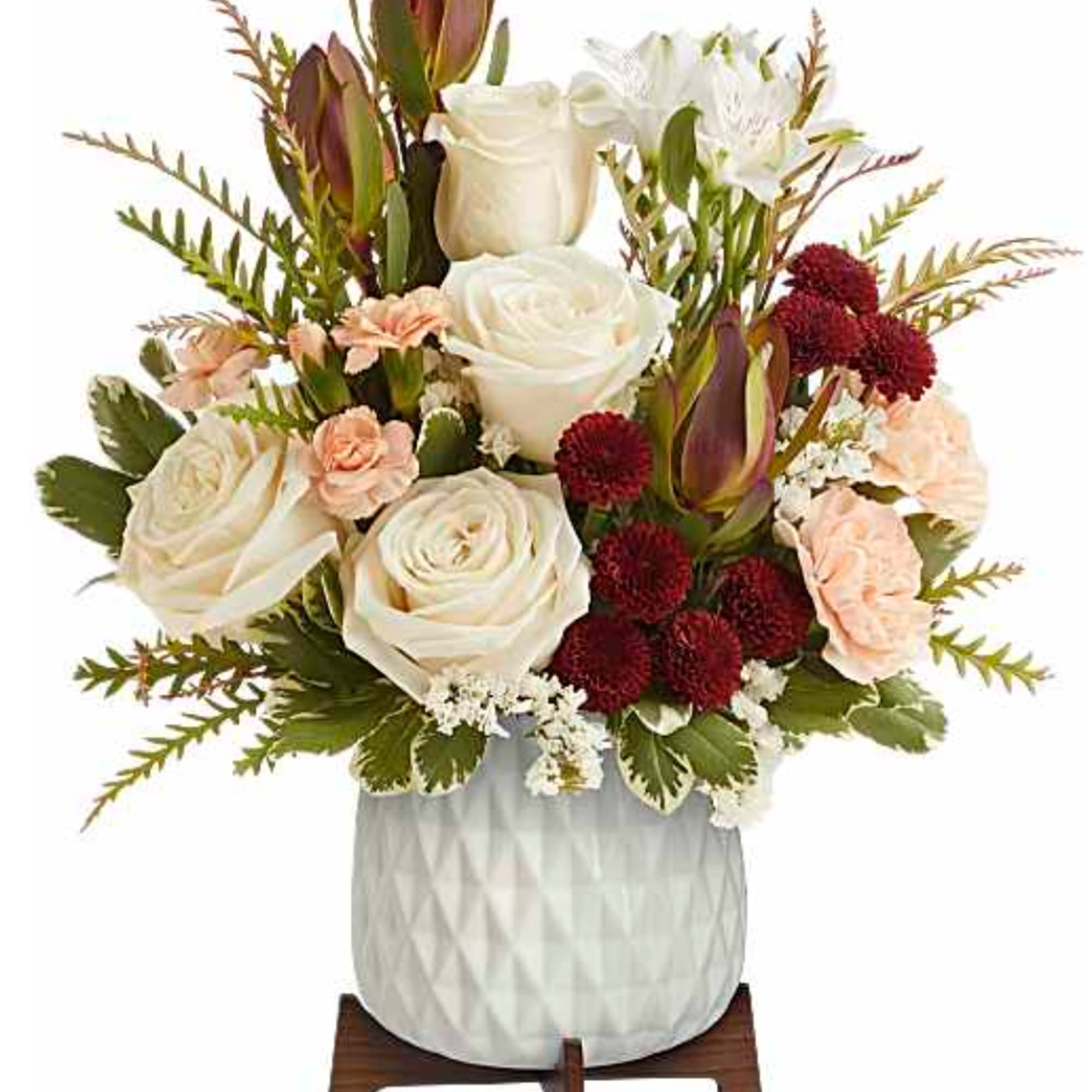 White roses and peach carnations in a white vase