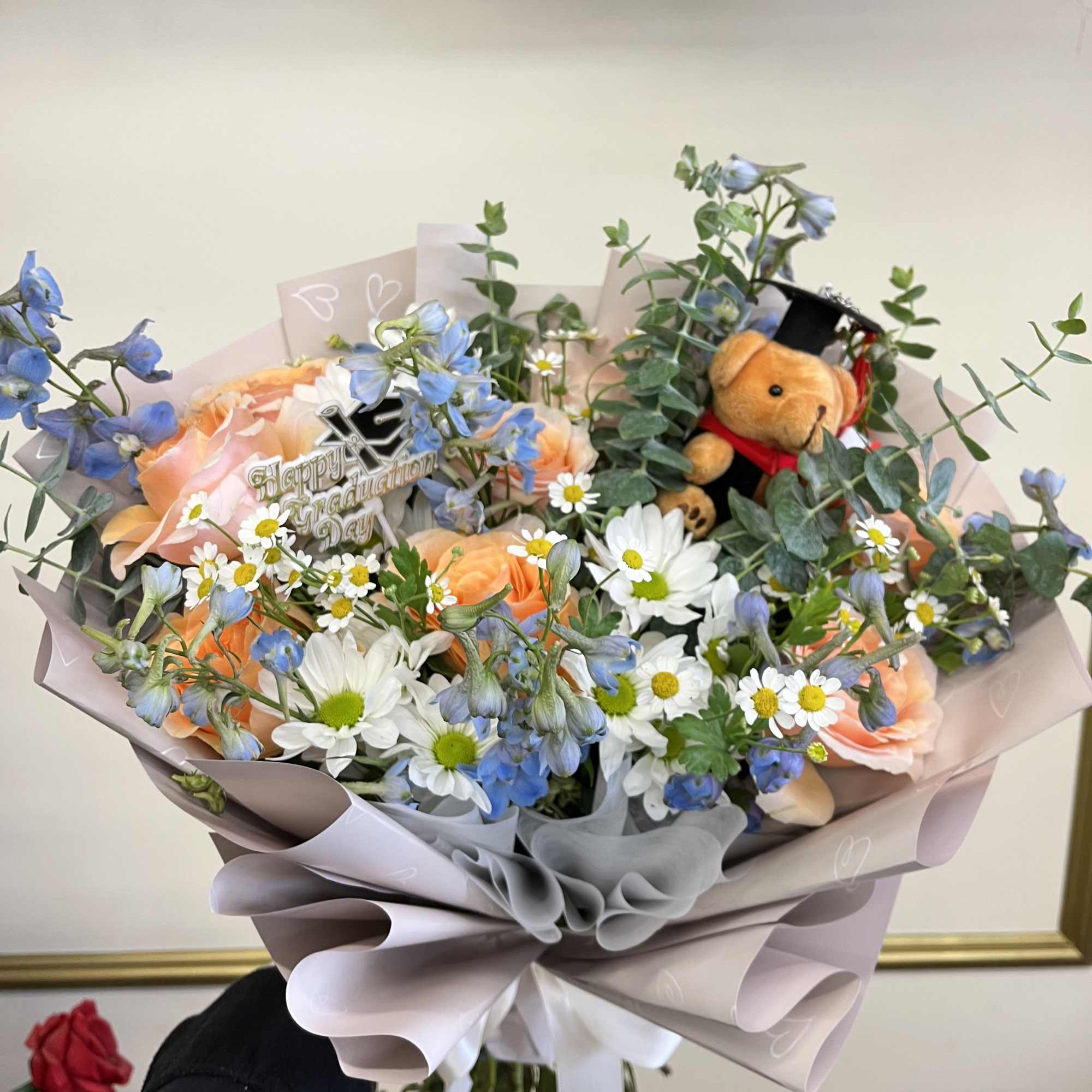 Celebrate their achievement with a beautifully crafted graduation bouquet featuring soft peach