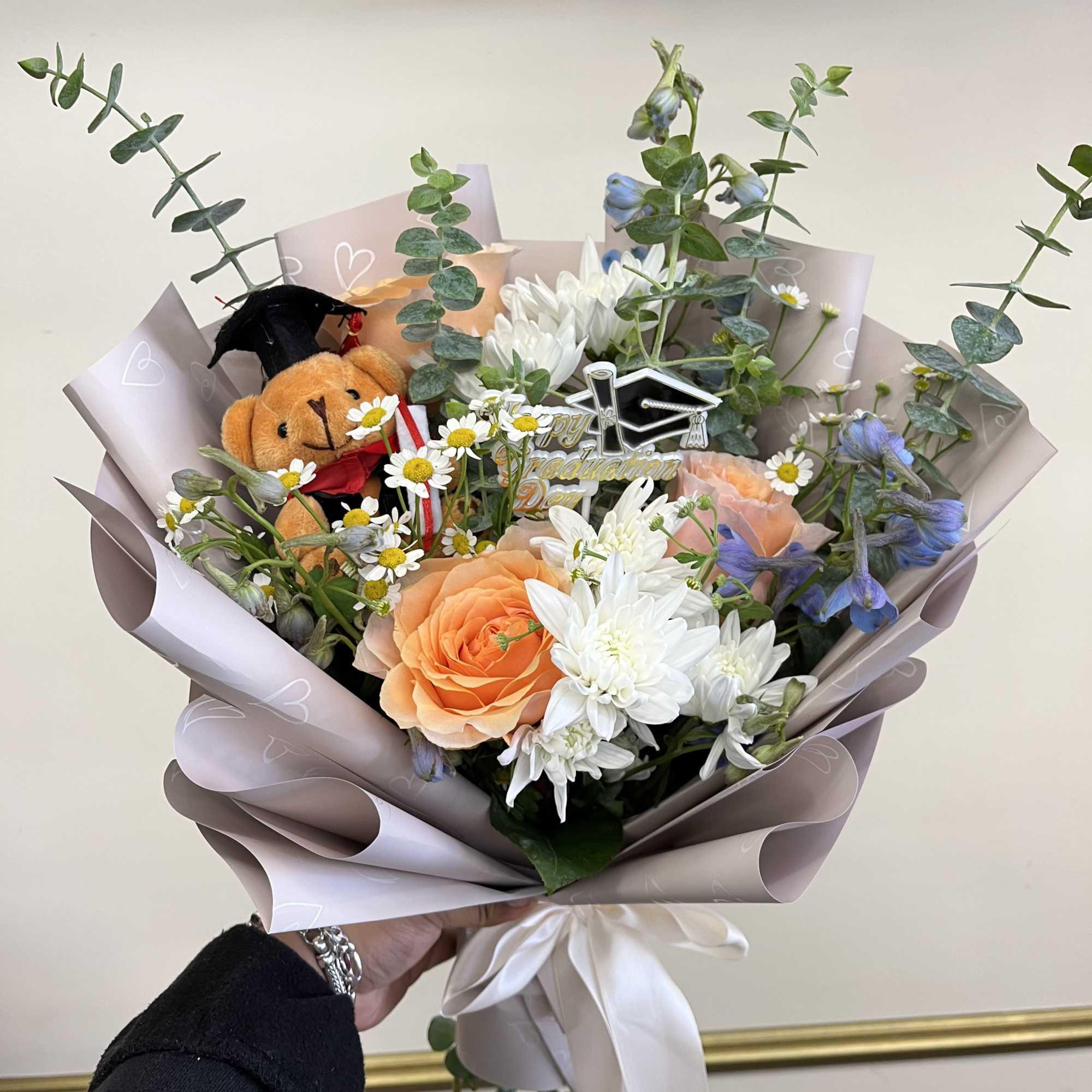 Celebrate their achievement with a beautifully crafted graduation bouquet featuring soft peach