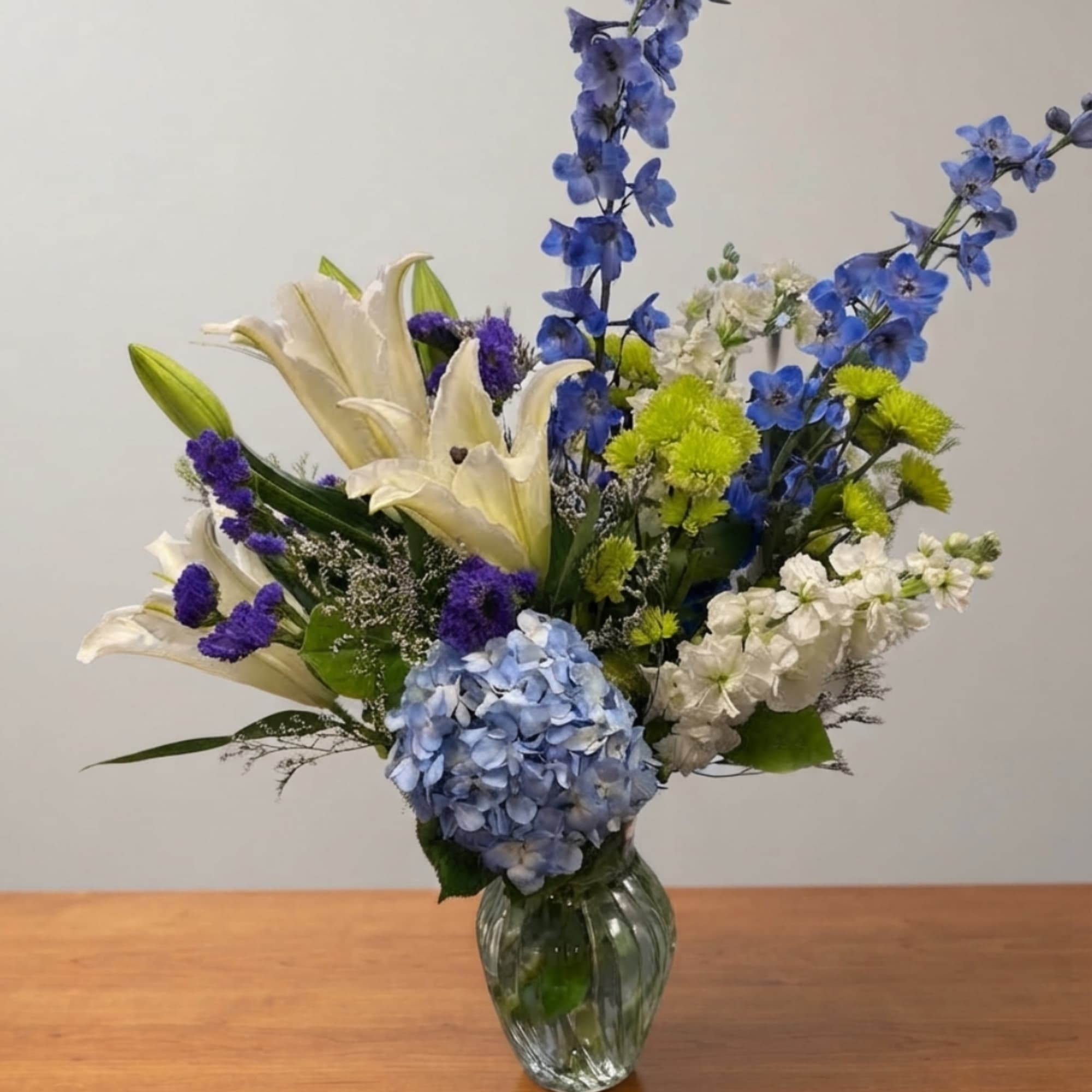 Blue and white floral arrangement in a clear glass vase