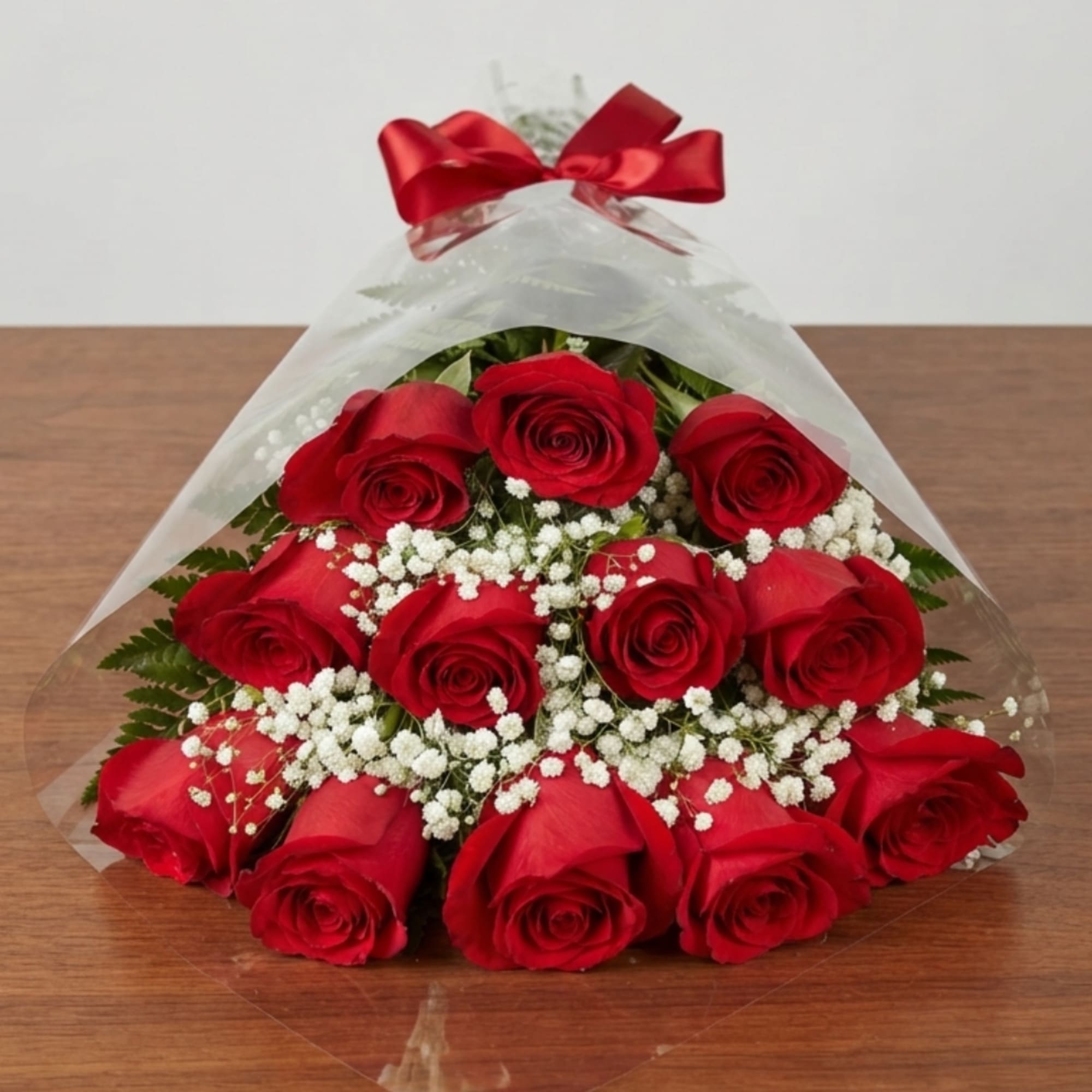 Bouquet of red roses with white baby's breath in clear wrap and a red bow
