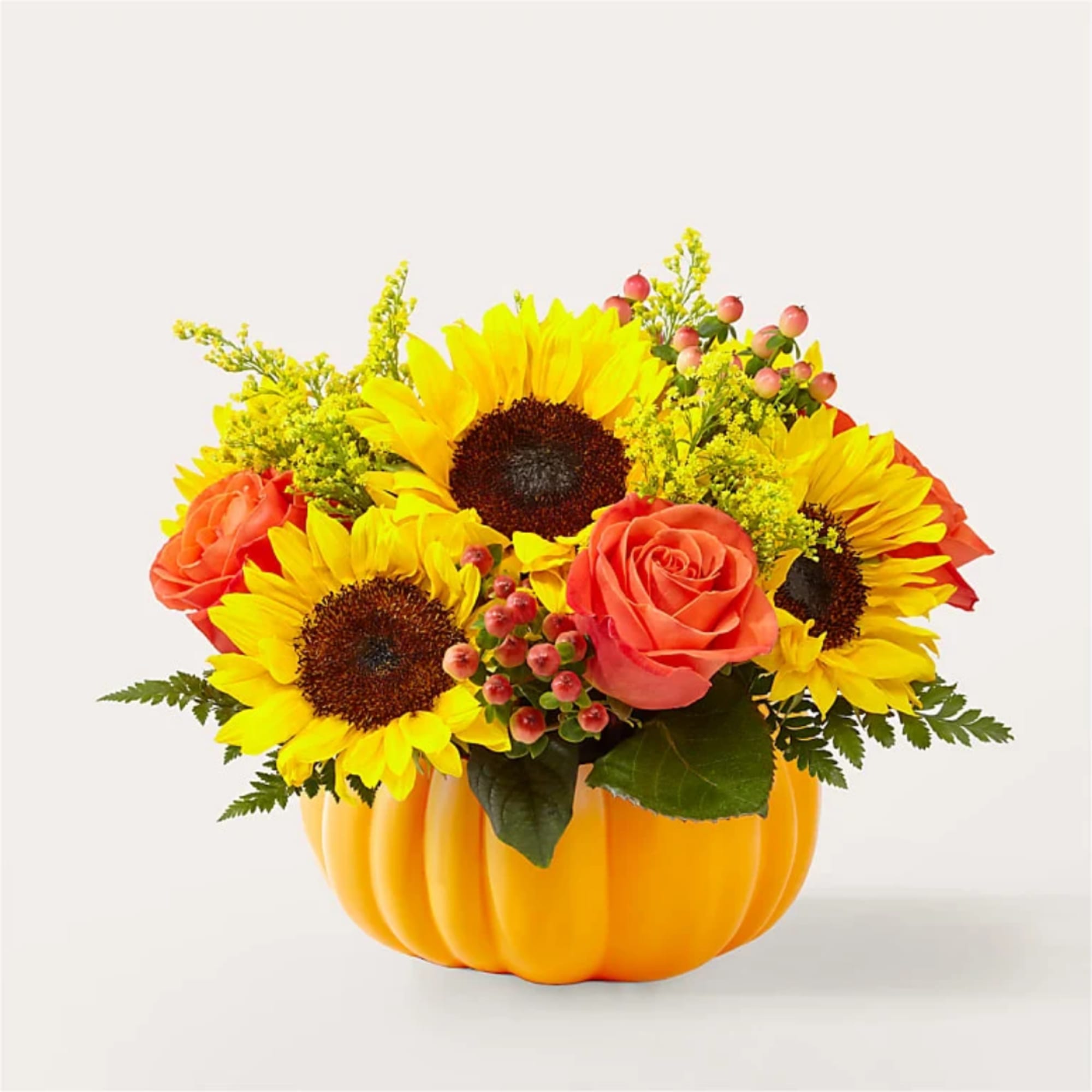 Sunflowers and coral roses arranged in a pumpkin-shaped container