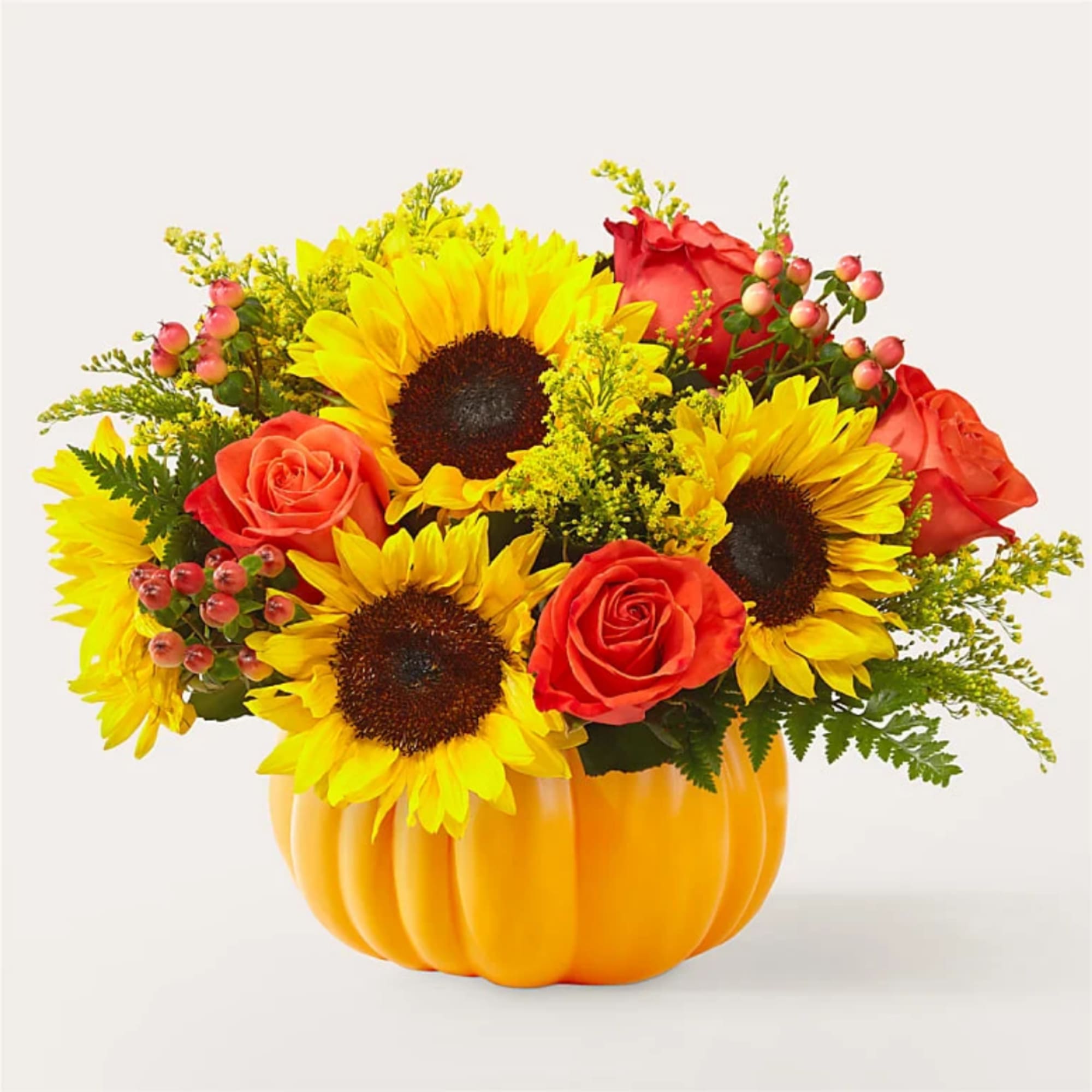 Sunflowers and red roses arranged in a pumpkin-shaped container