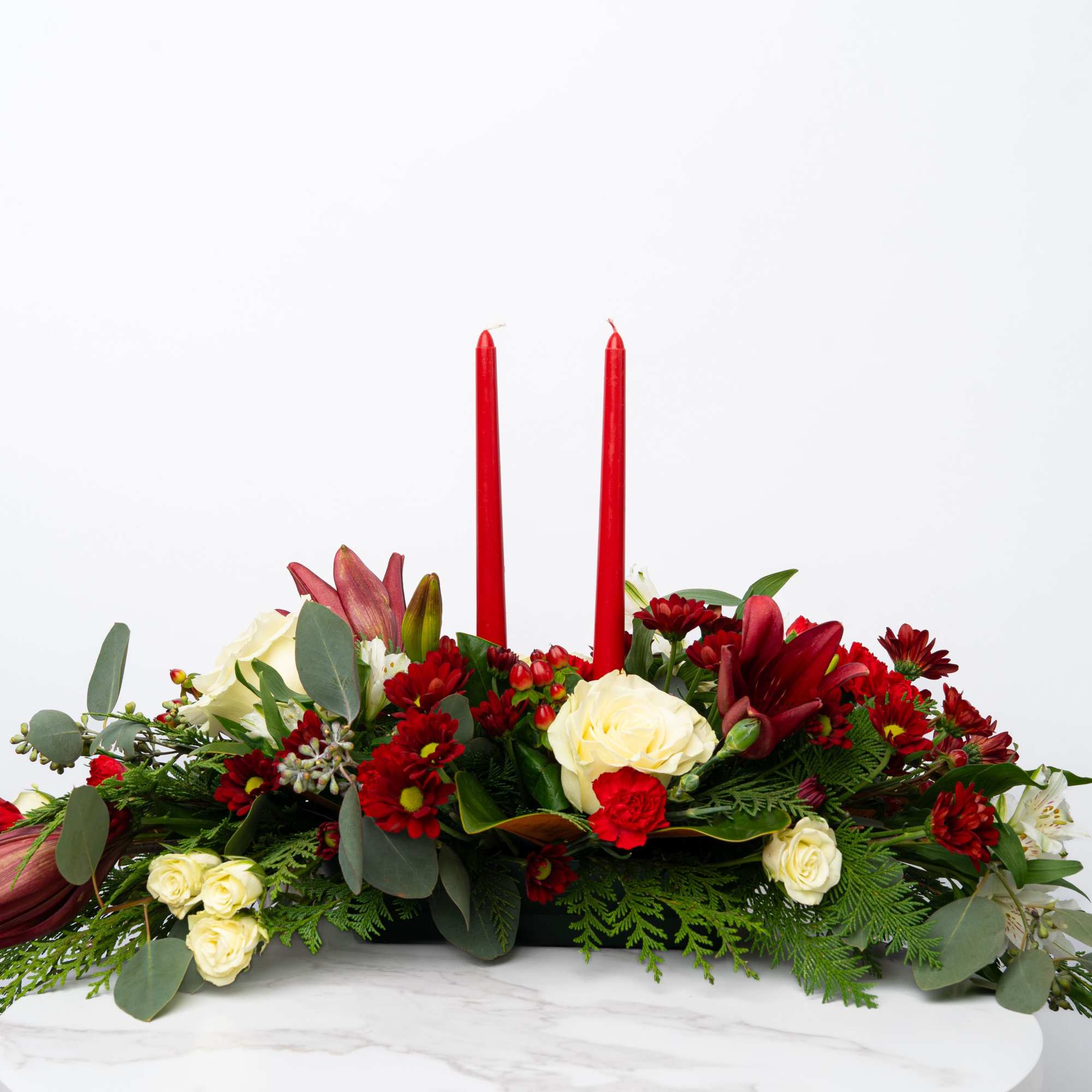 Red and cream floral centerpiece with two red candles
