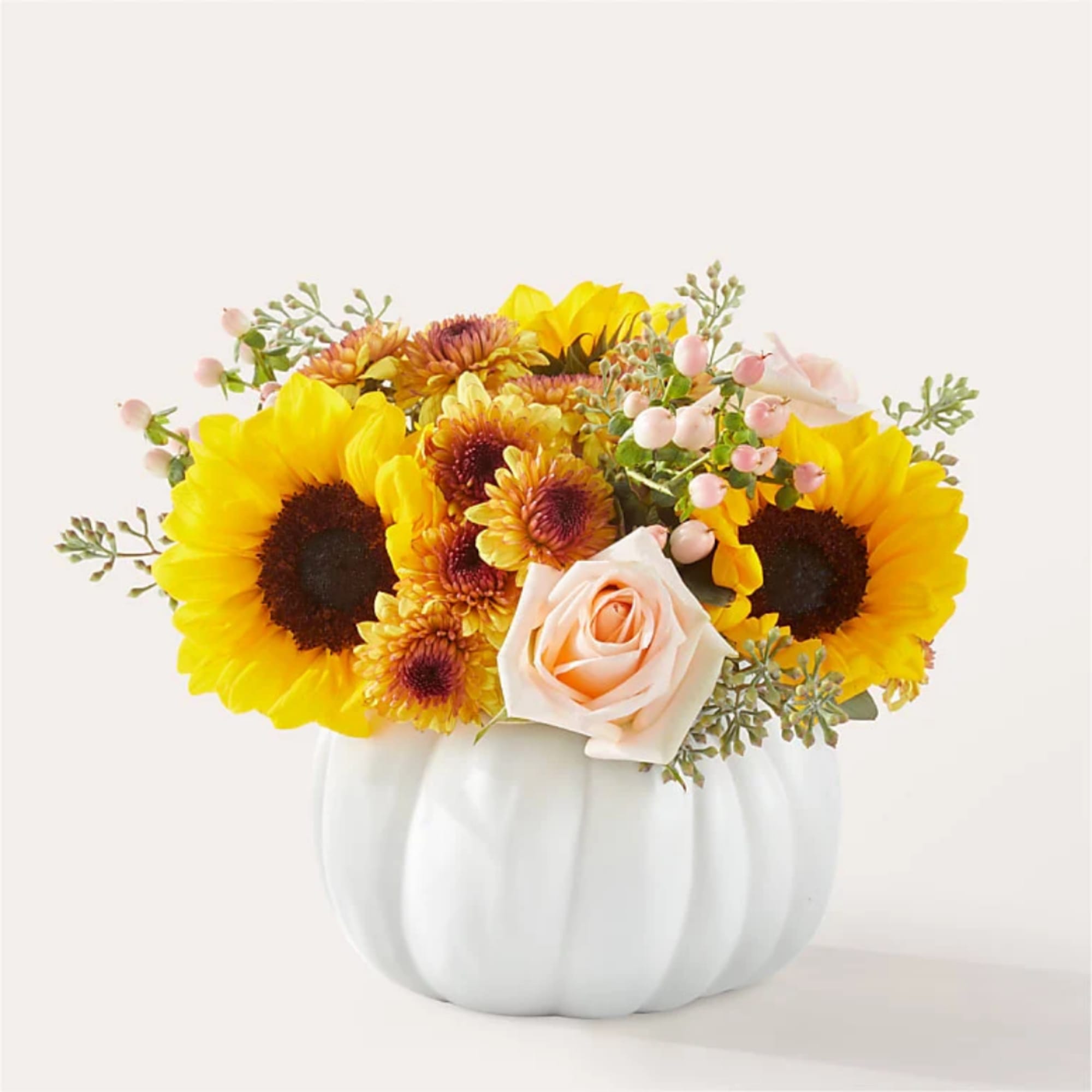 Sunflower and rose arrangement in a white pumpkin vase