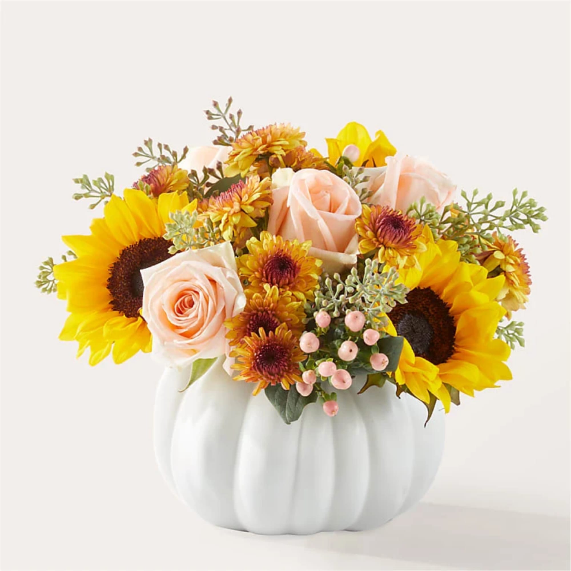 Sunflower and blush rose arrangement in a white pumpkin vase