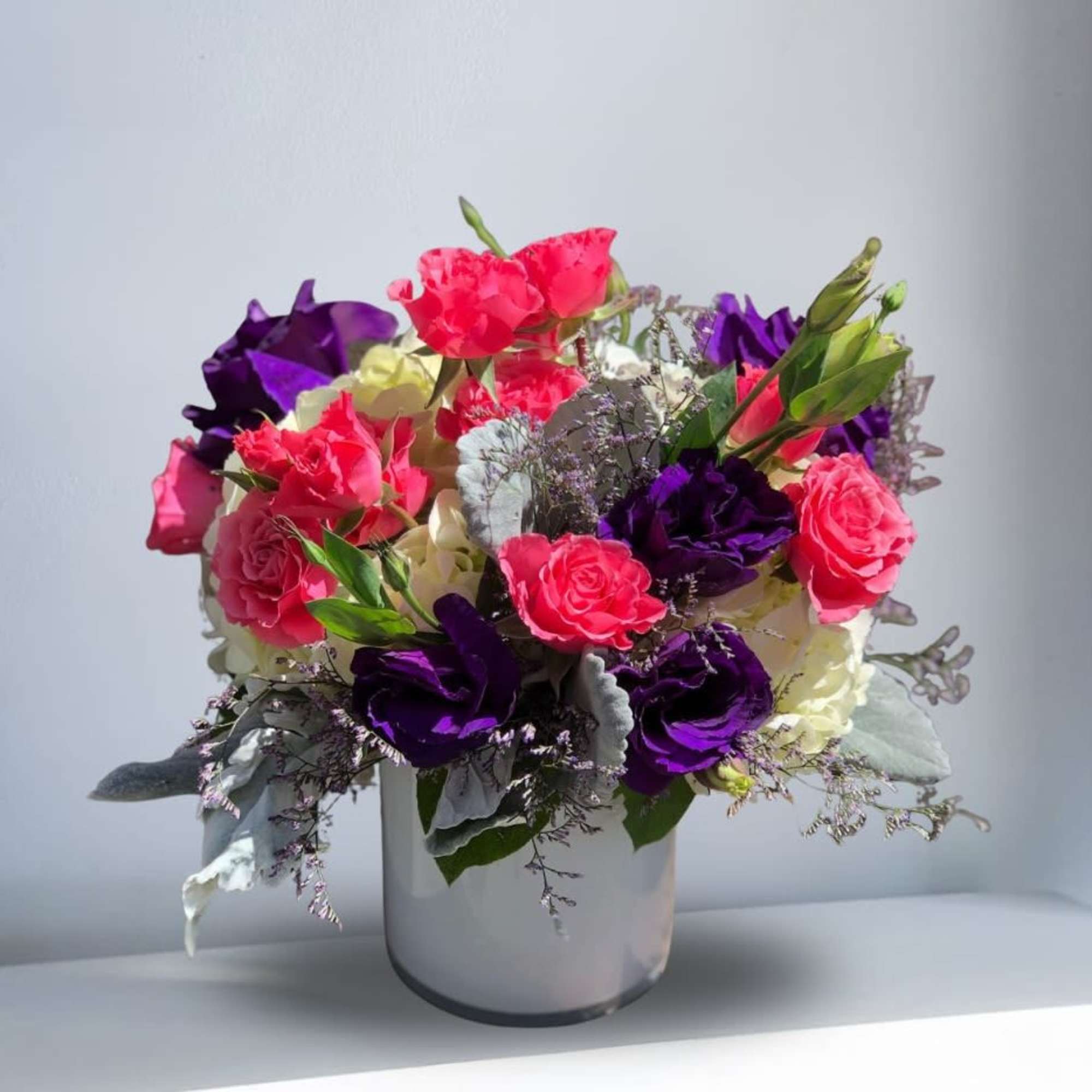 Turn heads with this striking, modern arrangement! Deep, velvety purples meet vibrant