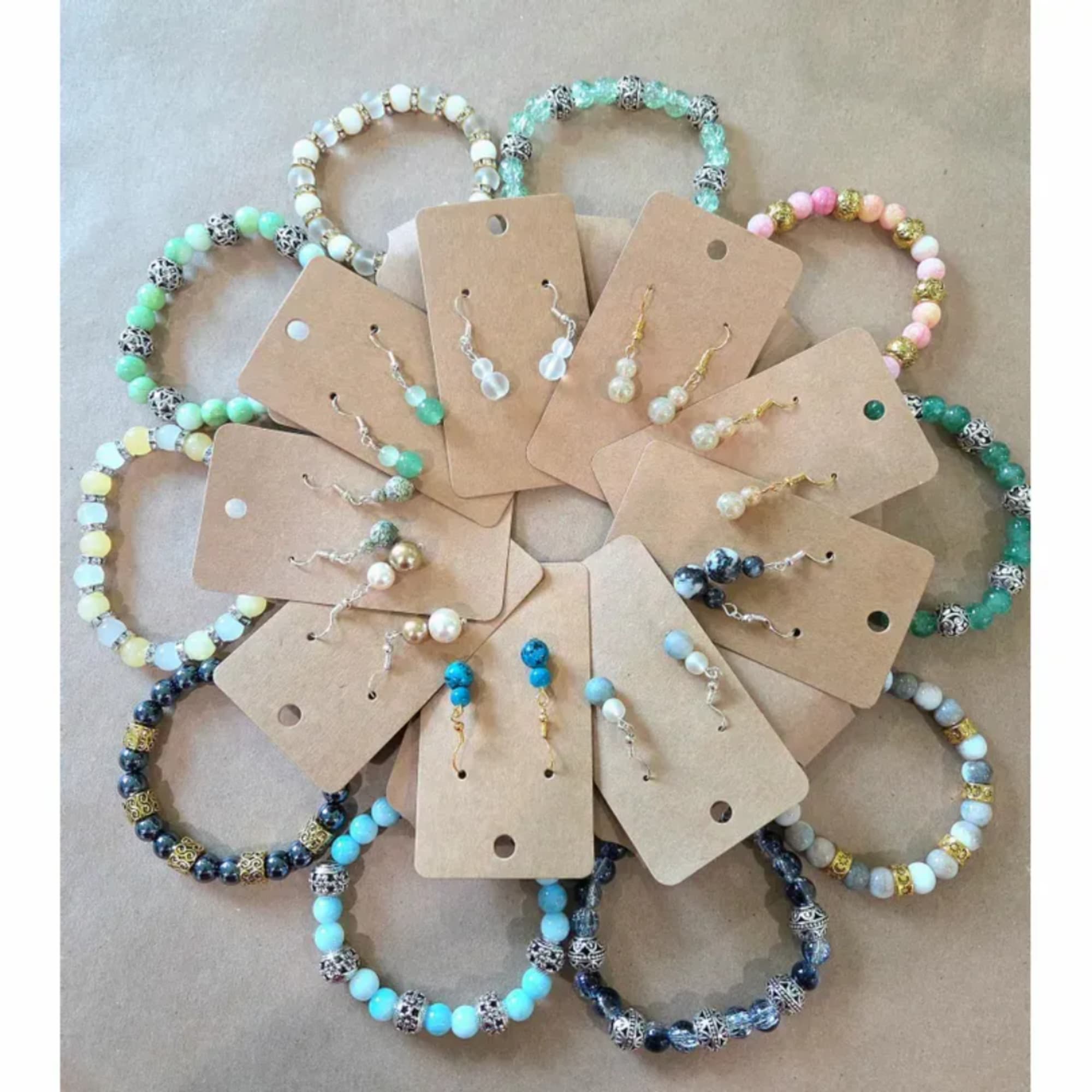 Assorted beaded bracelets and dangling earrings on kraft display cards