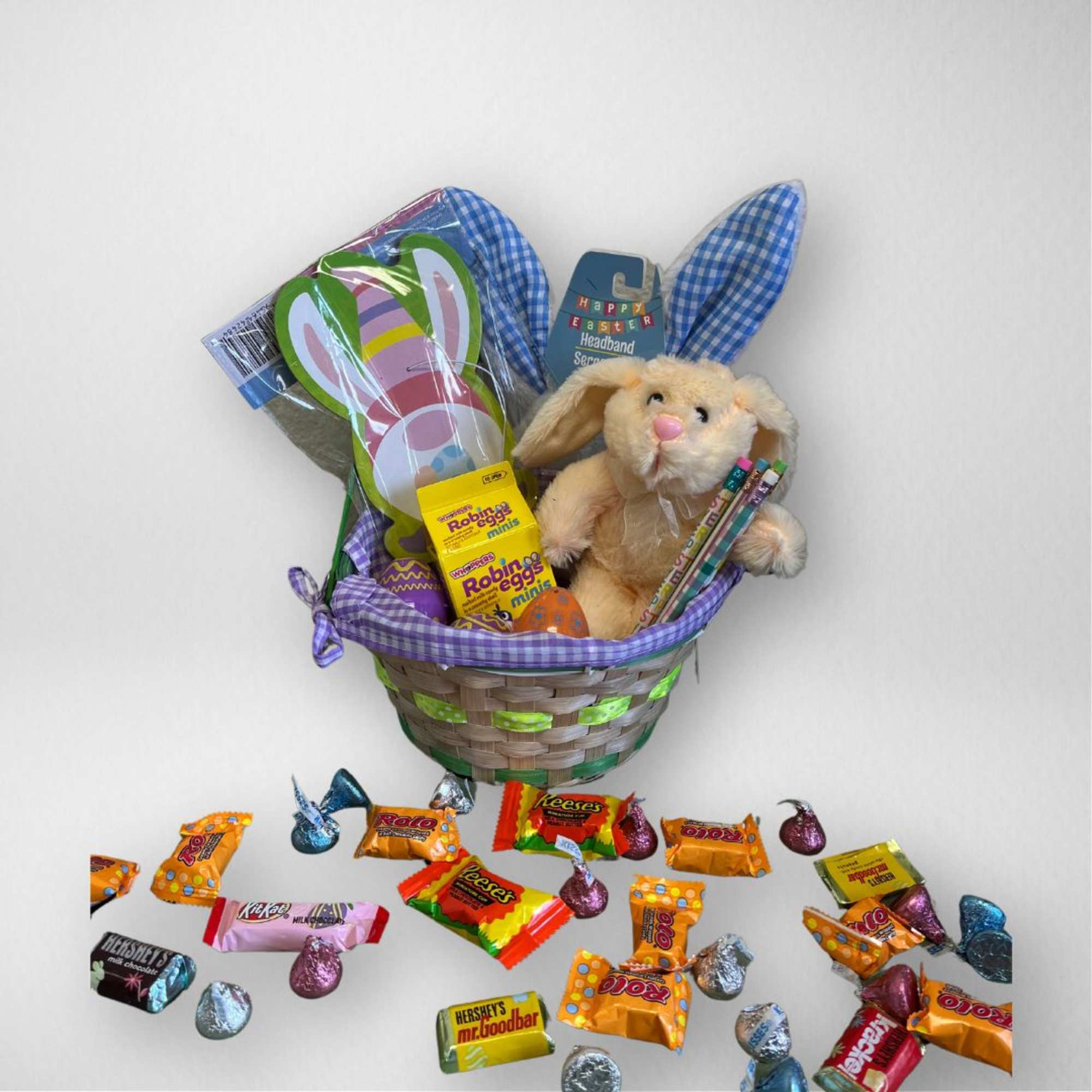 Easter gift basket with plush bunny, bunny-ear headband, and assorted candies.