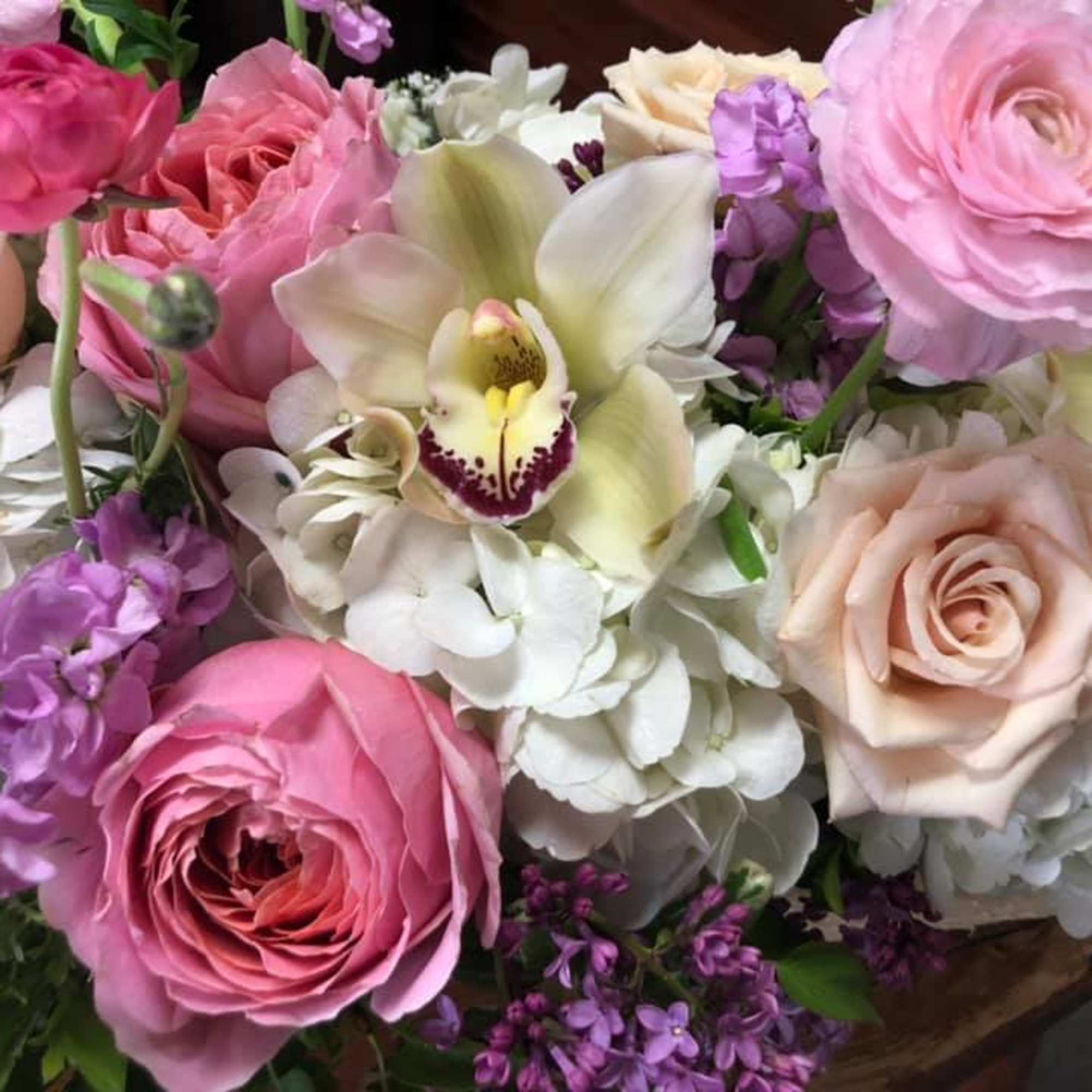 Bouquet of pink and cream roses with white orchids and purple flowers