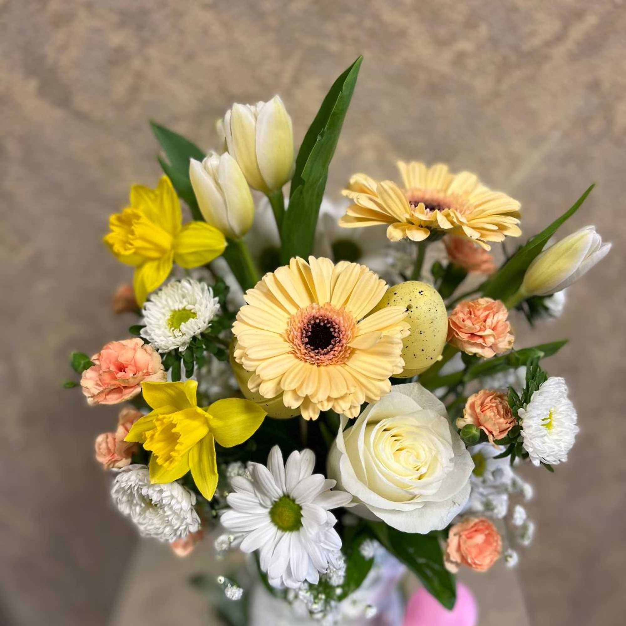 Mixed bouquet with yellow gerbera daisies, white roses, and daffodils in a vase