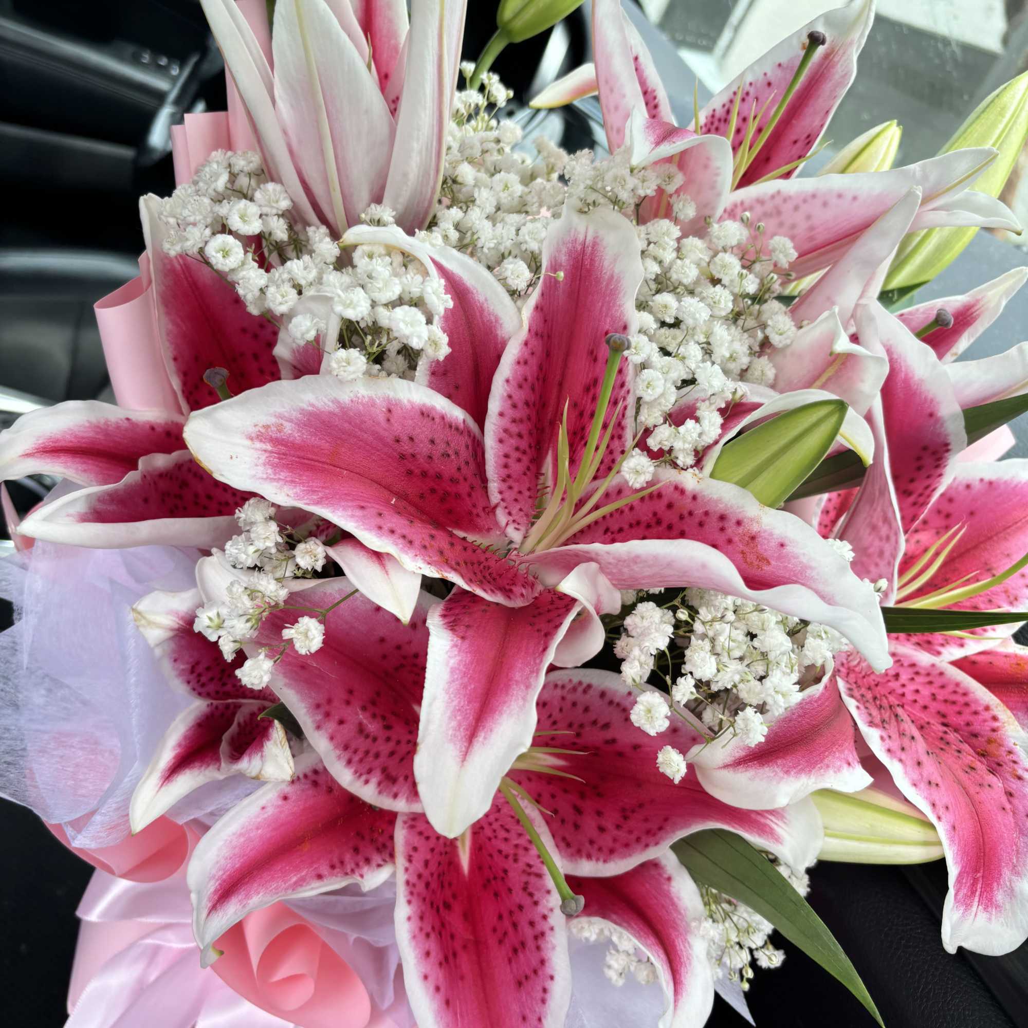 Bouquet of pink stargazer lilies with white baby's breath and pink ribbon