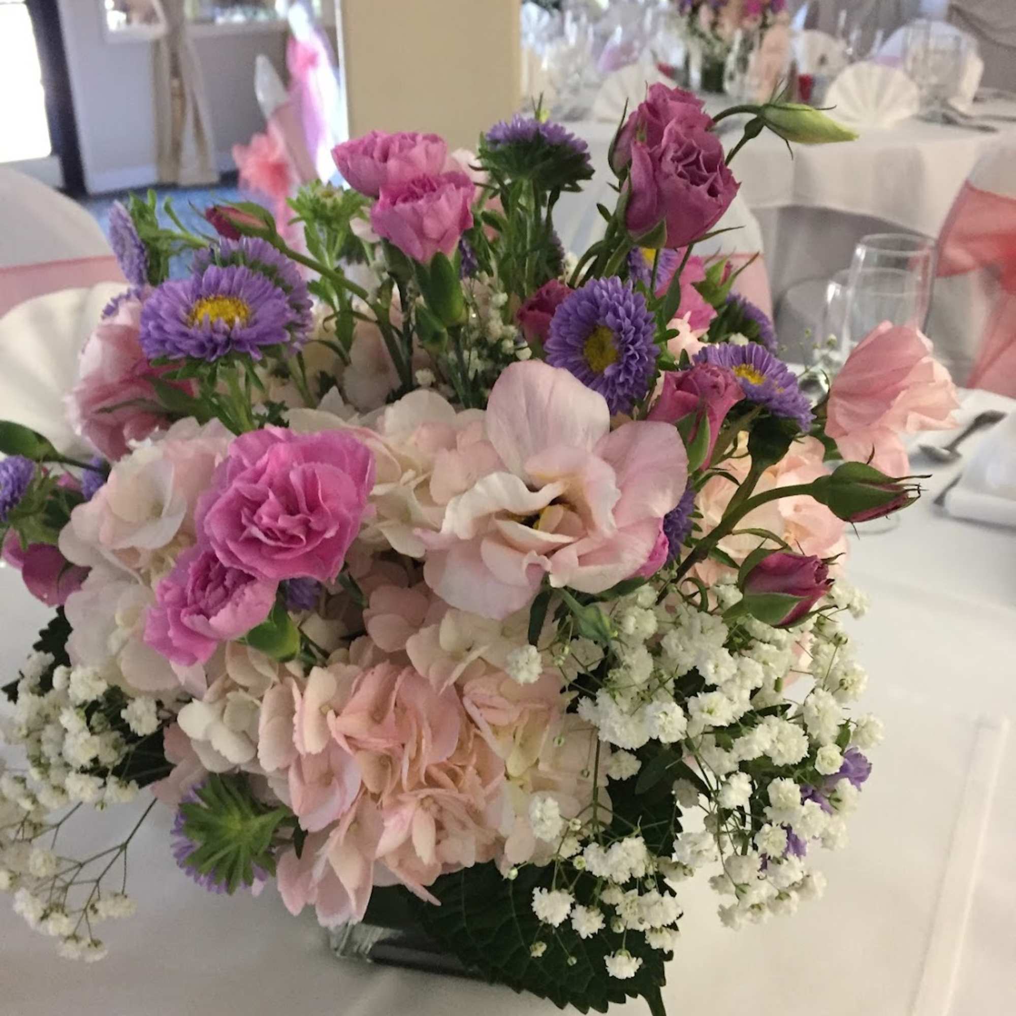 Sweet Pea centerpiece has Magenta and Pink Lisianthus, Purple Matsumoto Asters, Pink