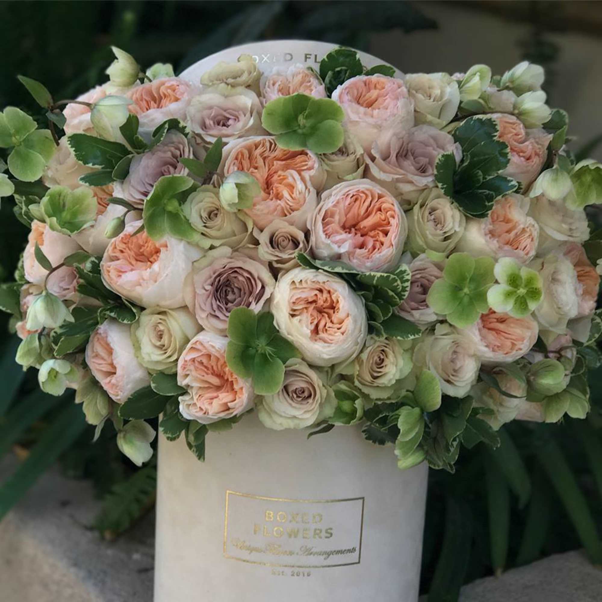 Bouquet of blush and cream roses in a white hat box