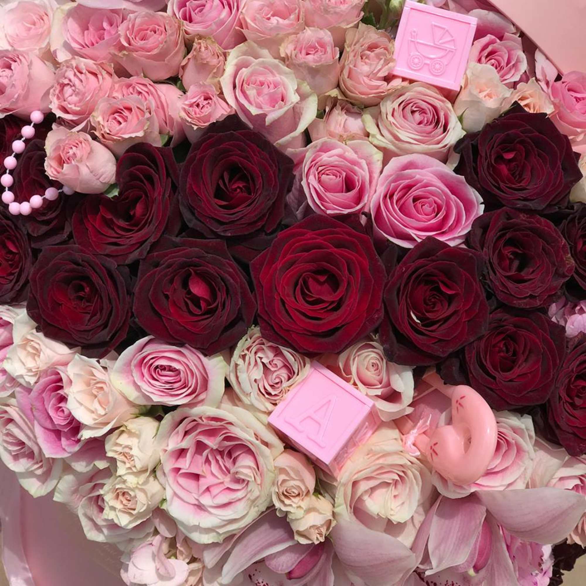 Bouquet of pink and burgundy roses with small pink decorative blocks