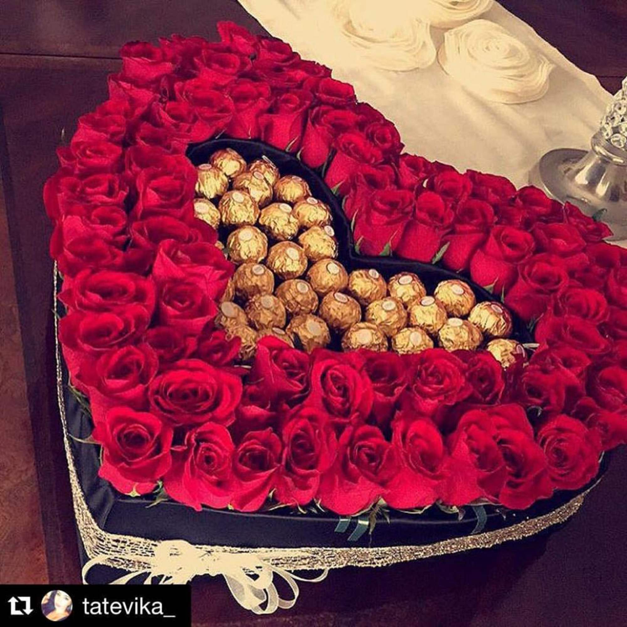 Heart-shaped box of red roses filled with gold-wrapped chocolates