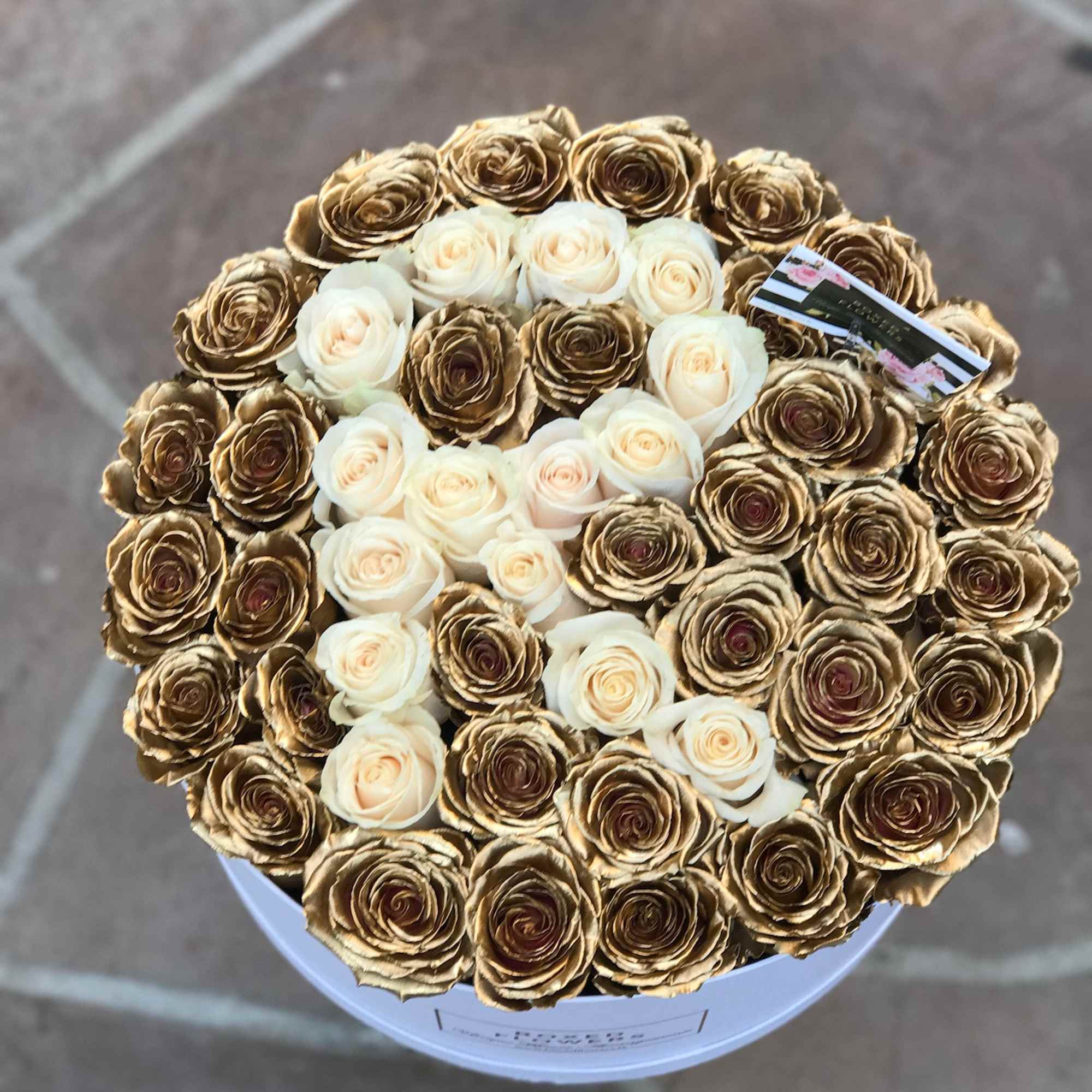 Round bouquet of cream and gold roses in a white box