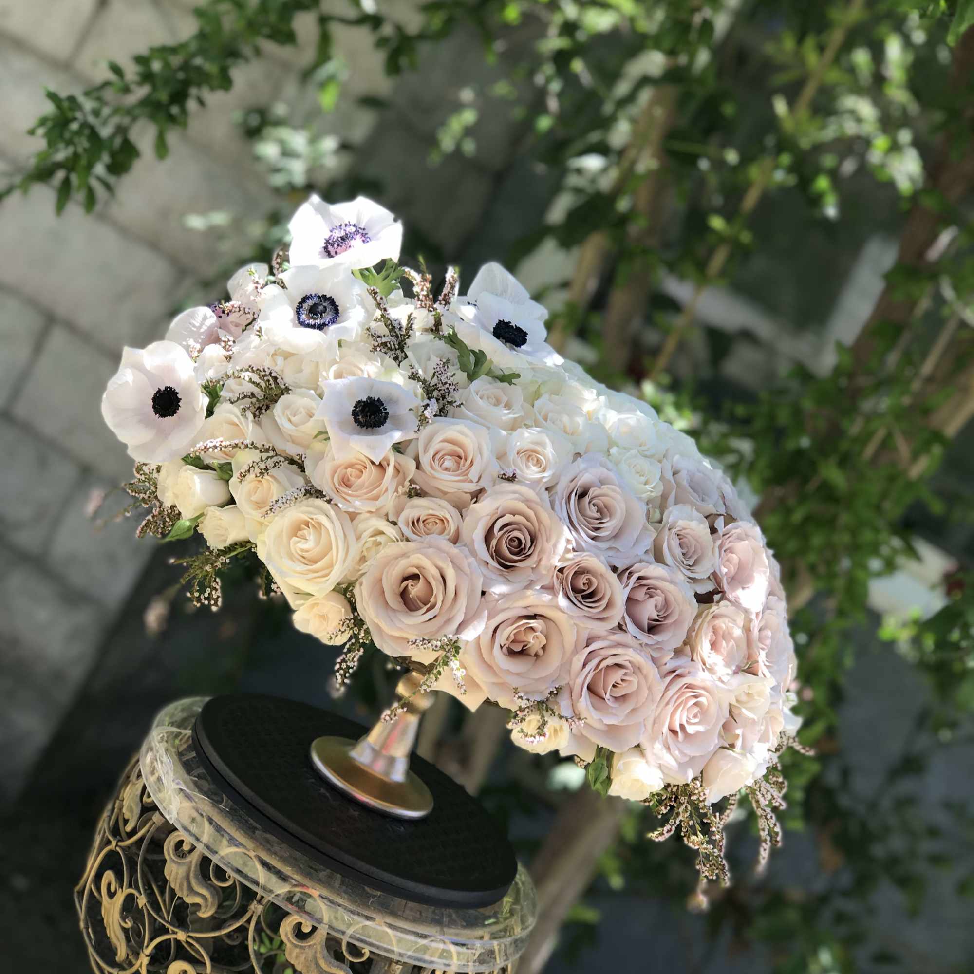 Blush and white rose bouquet with white anemones on an ornate stand