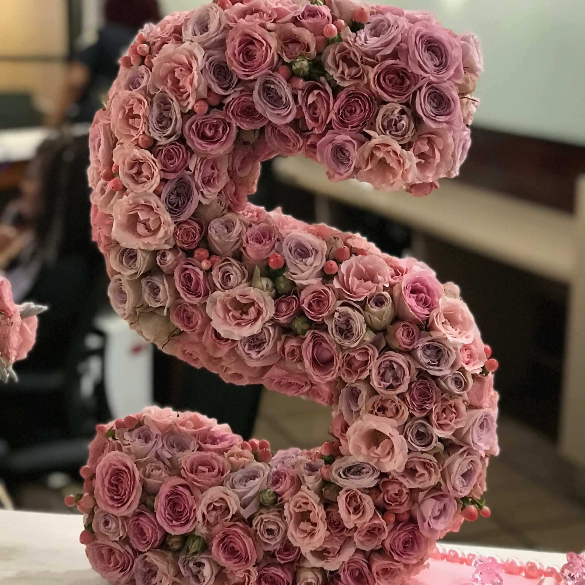 Pink rose letter arrangement shaped like an S on a tray
