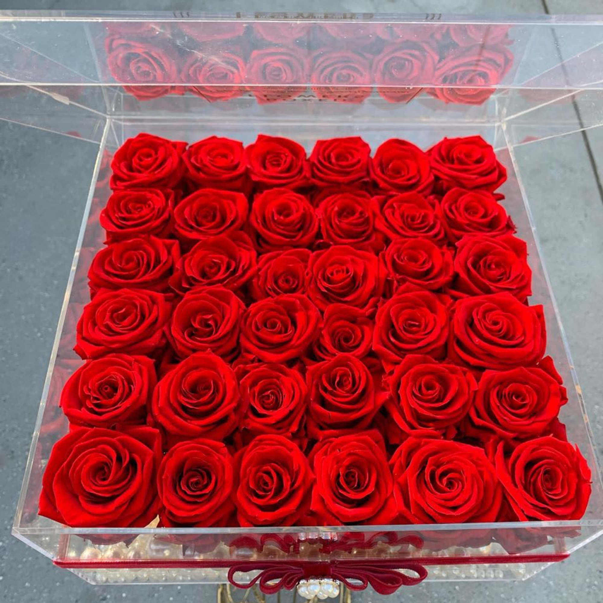 Box of red roses in a clear acrylic case