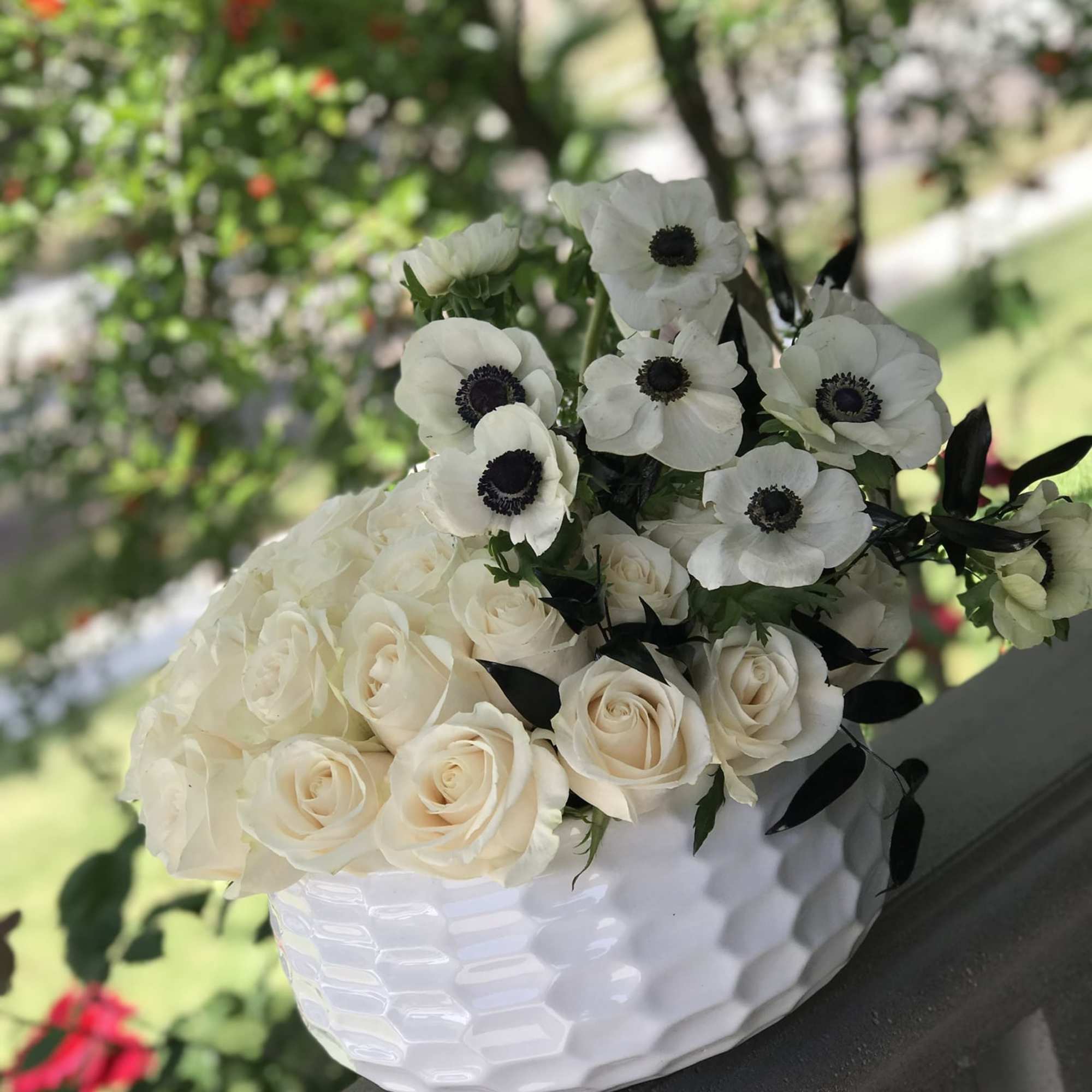 White roses and anemones in a white textured vase