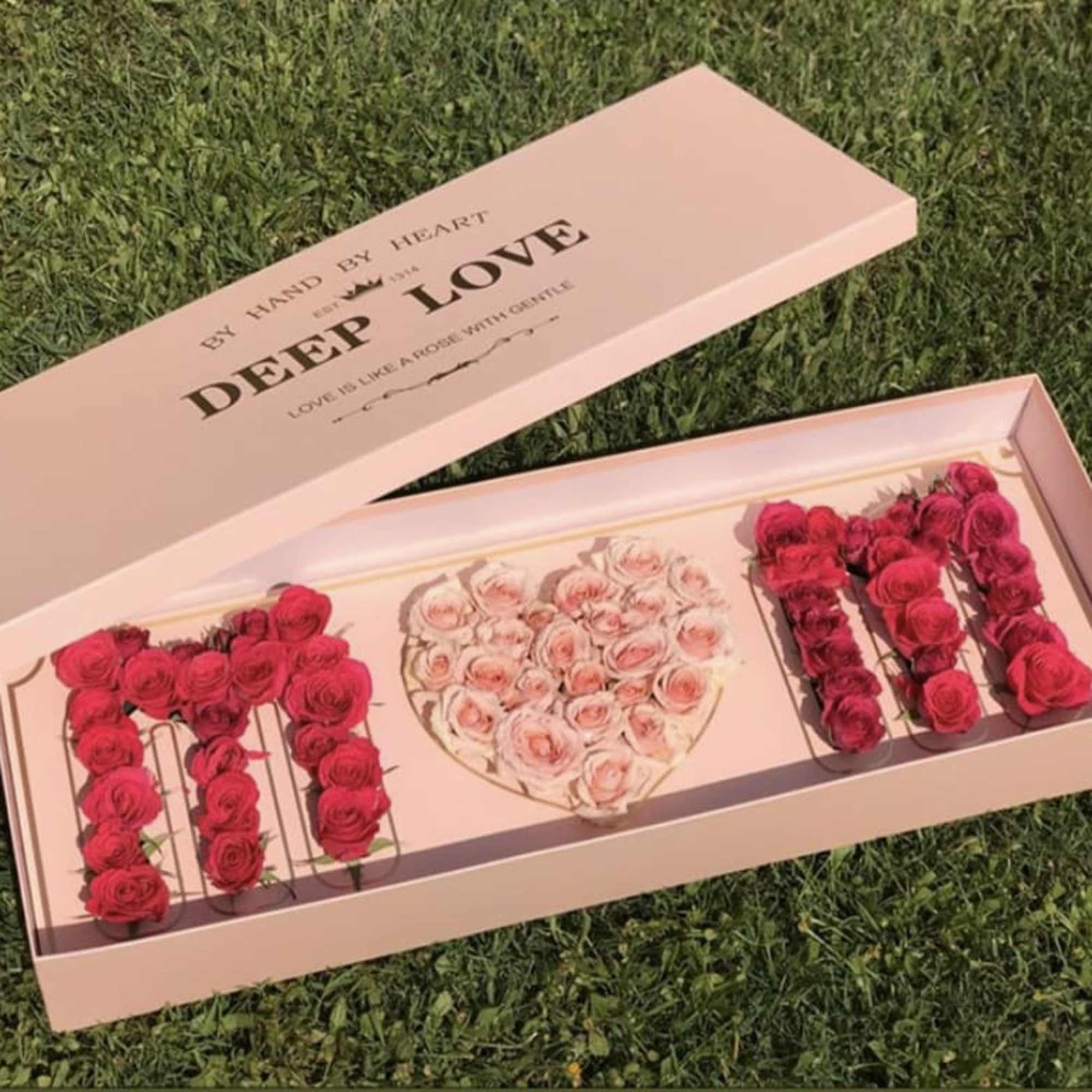 Pink rose gift box spelling "MOM" with a heart centerpiece